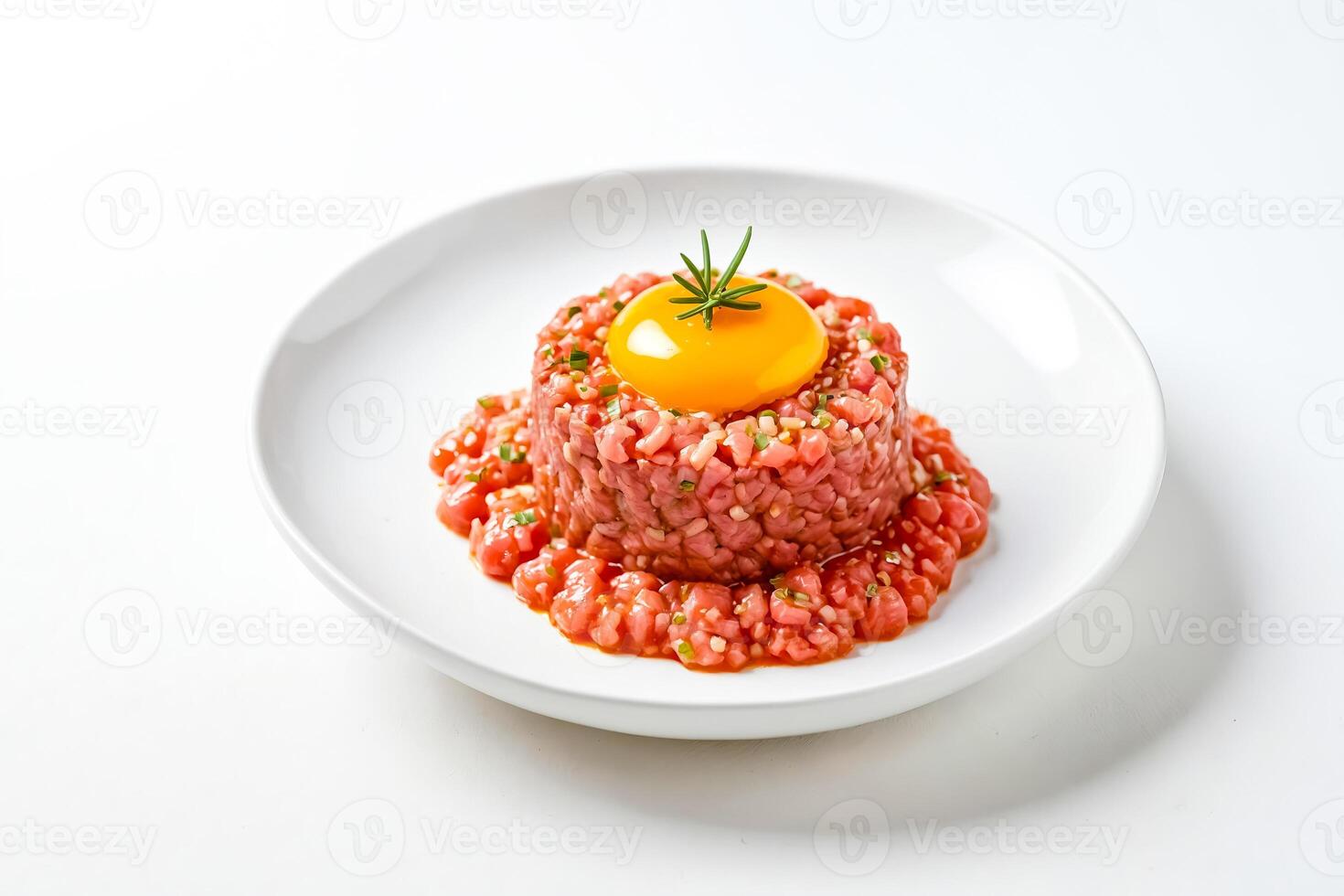 Beef Tartar with Raw Egg Yolk and Herbs on White Plate photo