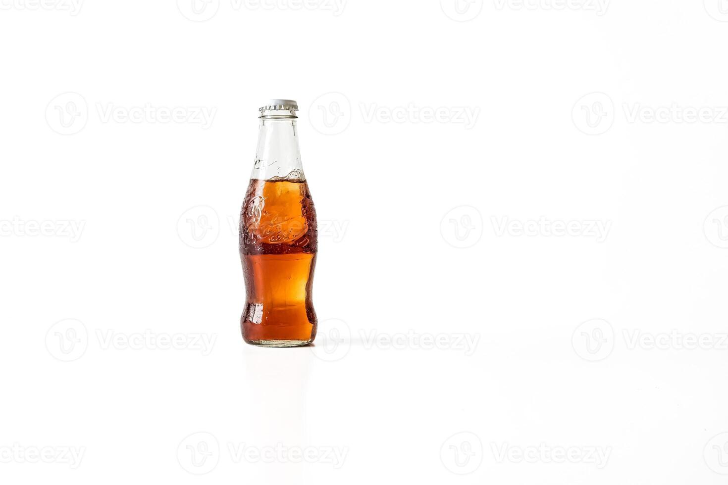 Glass bottle of cola on white background photo