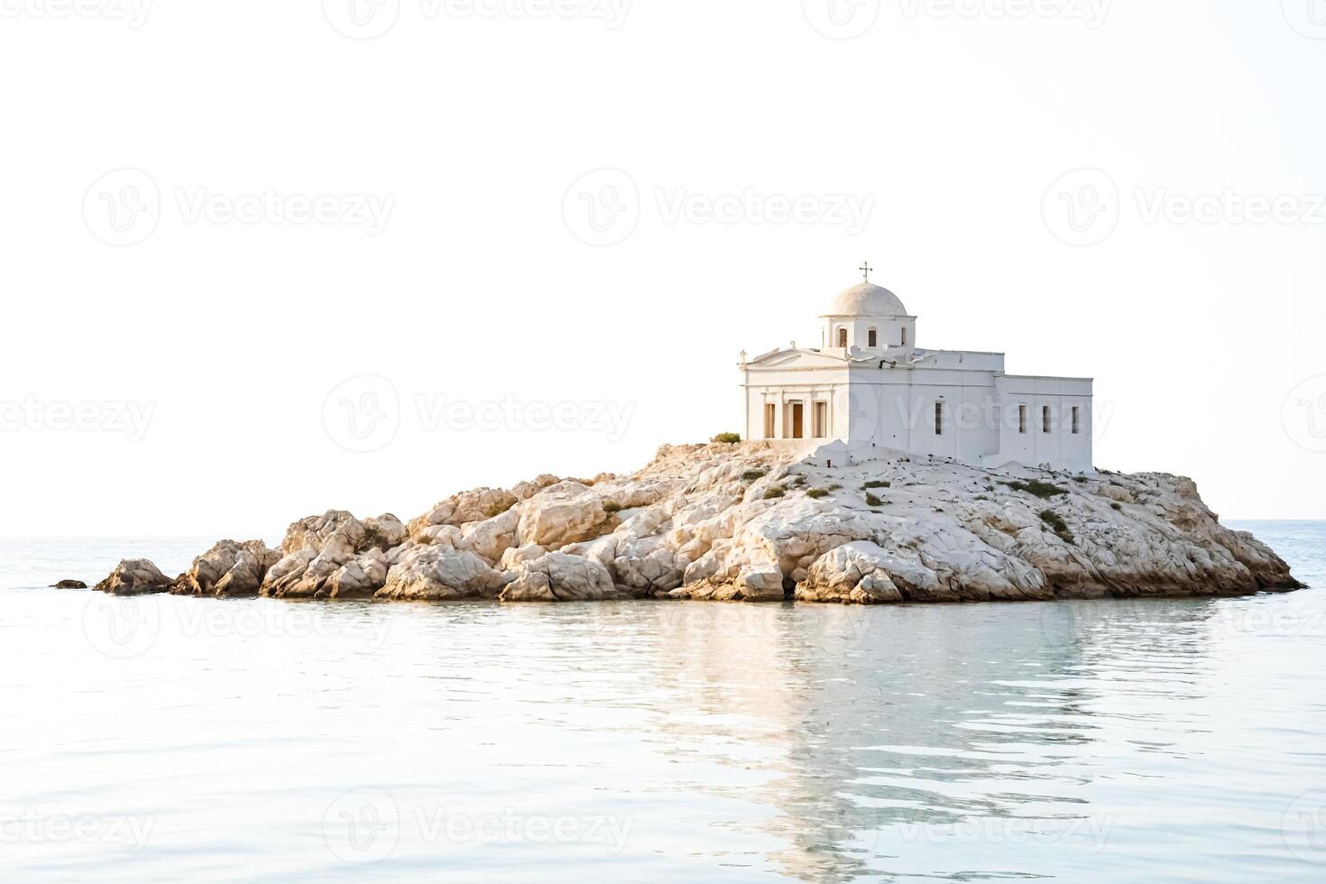 White Chapel on a Rocky Island in the Aegean Sea photo