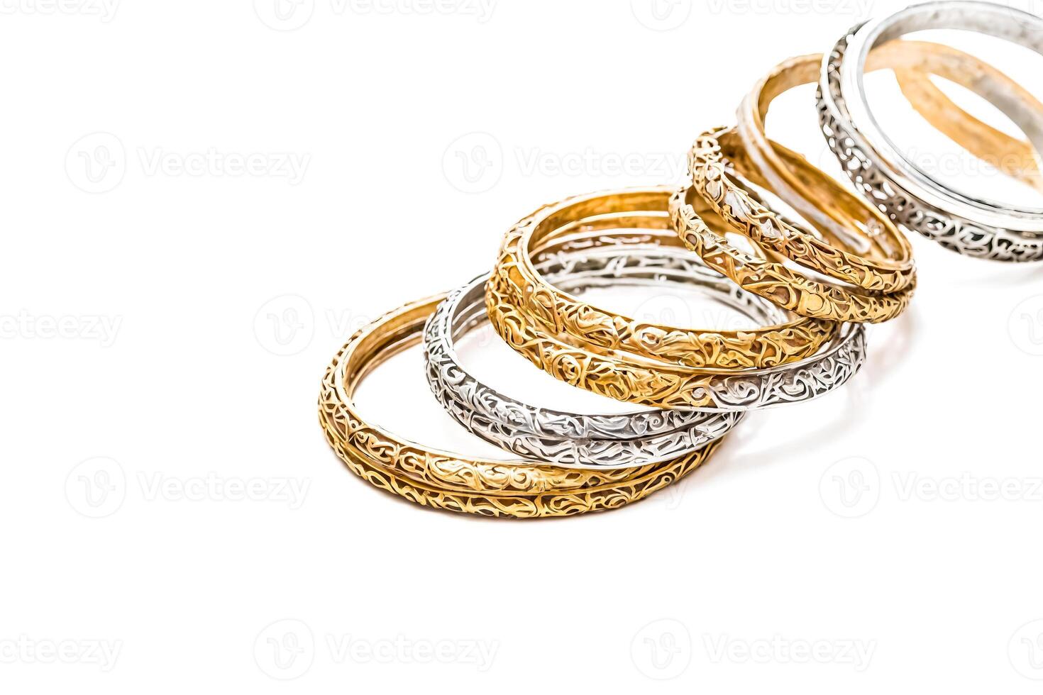 Stacked gold and silver bangles with intricate designs photo