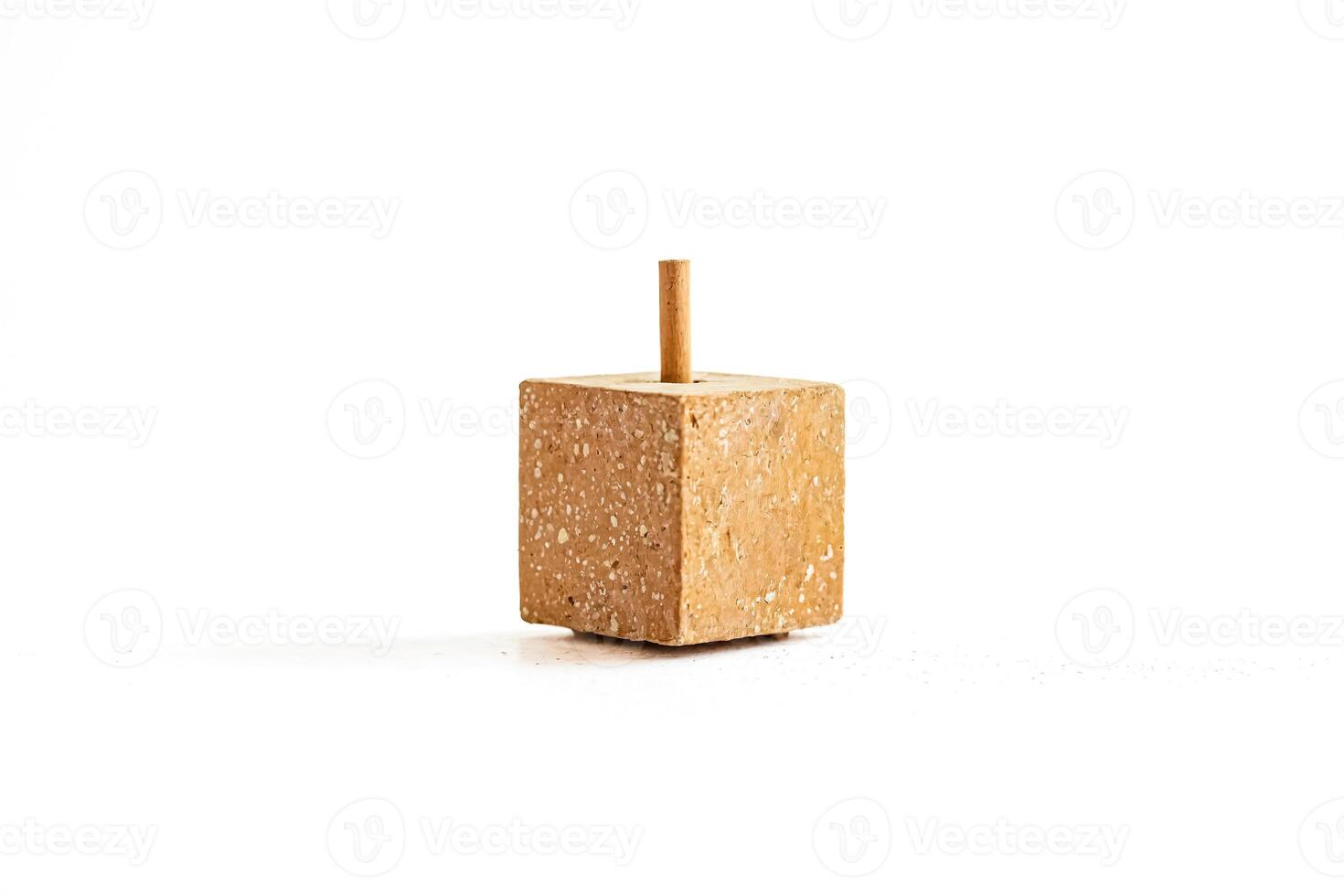 Concrete cube with a wooden stick on top photo