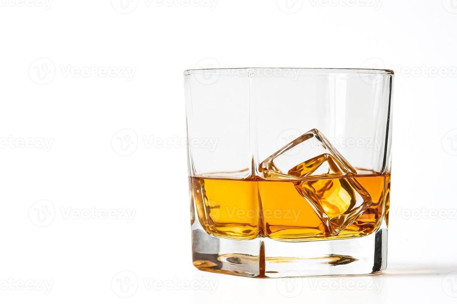 Glass of whiskey with ice cubes photo