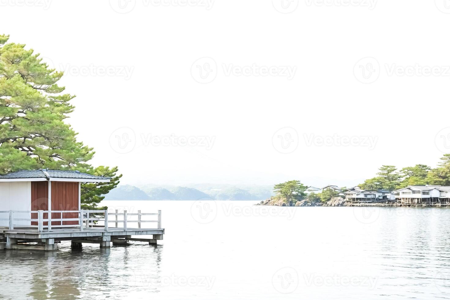 Wooden dock extending into a calm lake with a view of a mountain in the distance photo