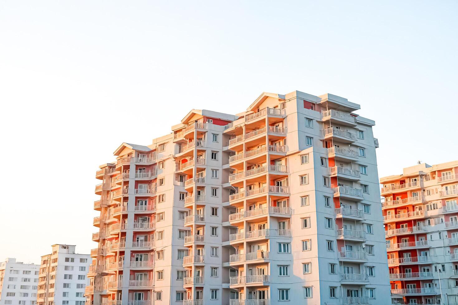 Apartment building with balconies and windows at sunset photo