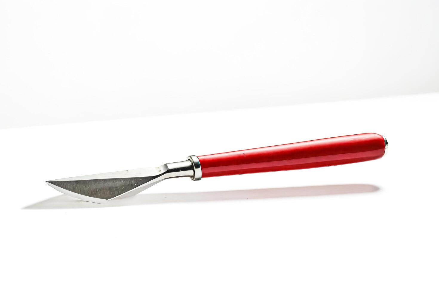 Red handled knife isolated on white background photo