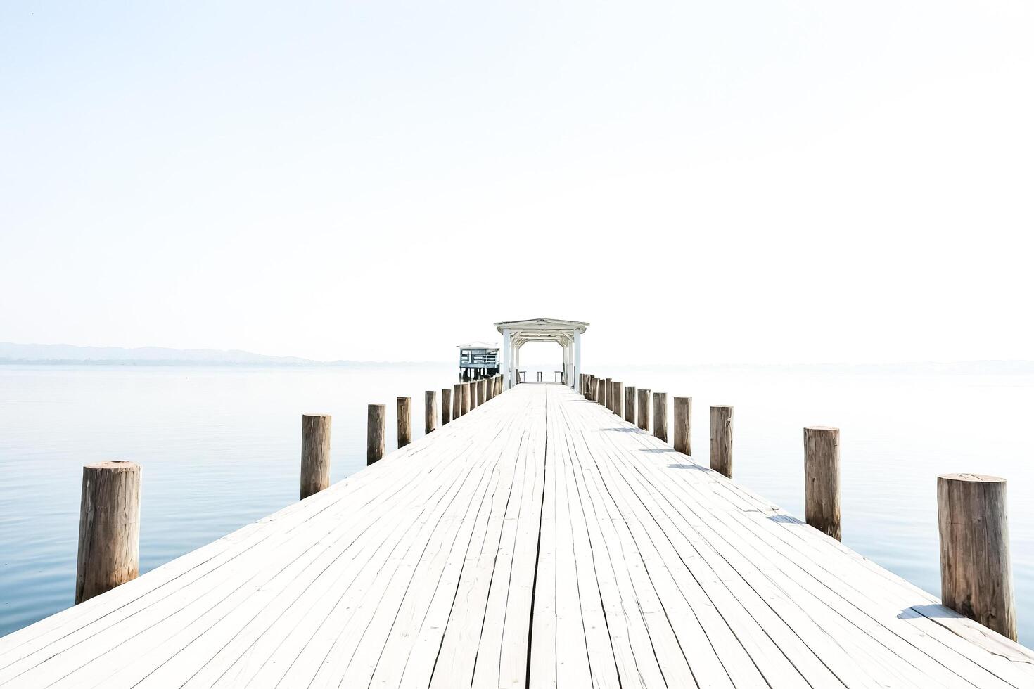Wooden Pier Leading to a Gazebo on a Calm Lake photo