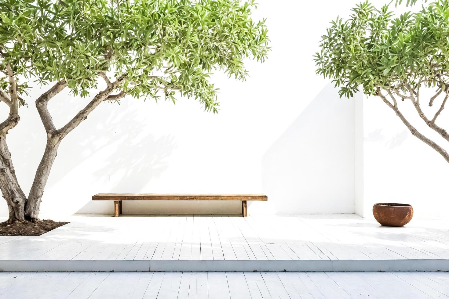 Minimalist White Patio with Wooden Bench and Greenery photo