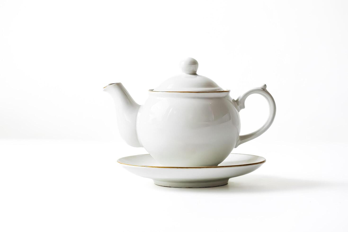 White Porcelain Teapot with Saucer on White Background photo