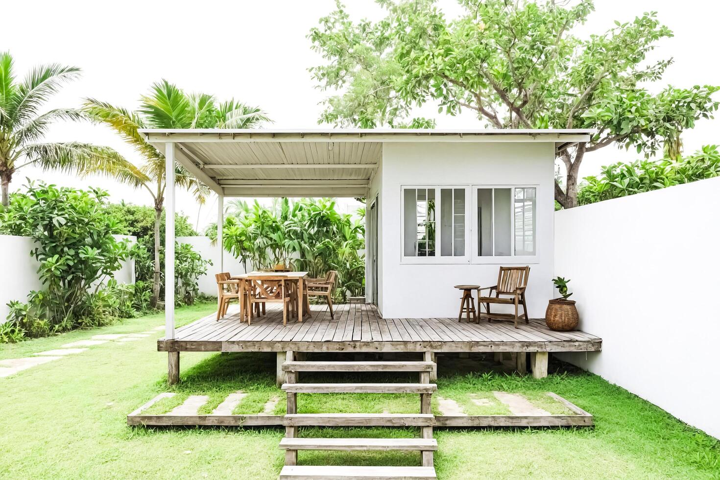 White Minimalist Cabana with Wooden Deck and Steps in Tropical Garden photo