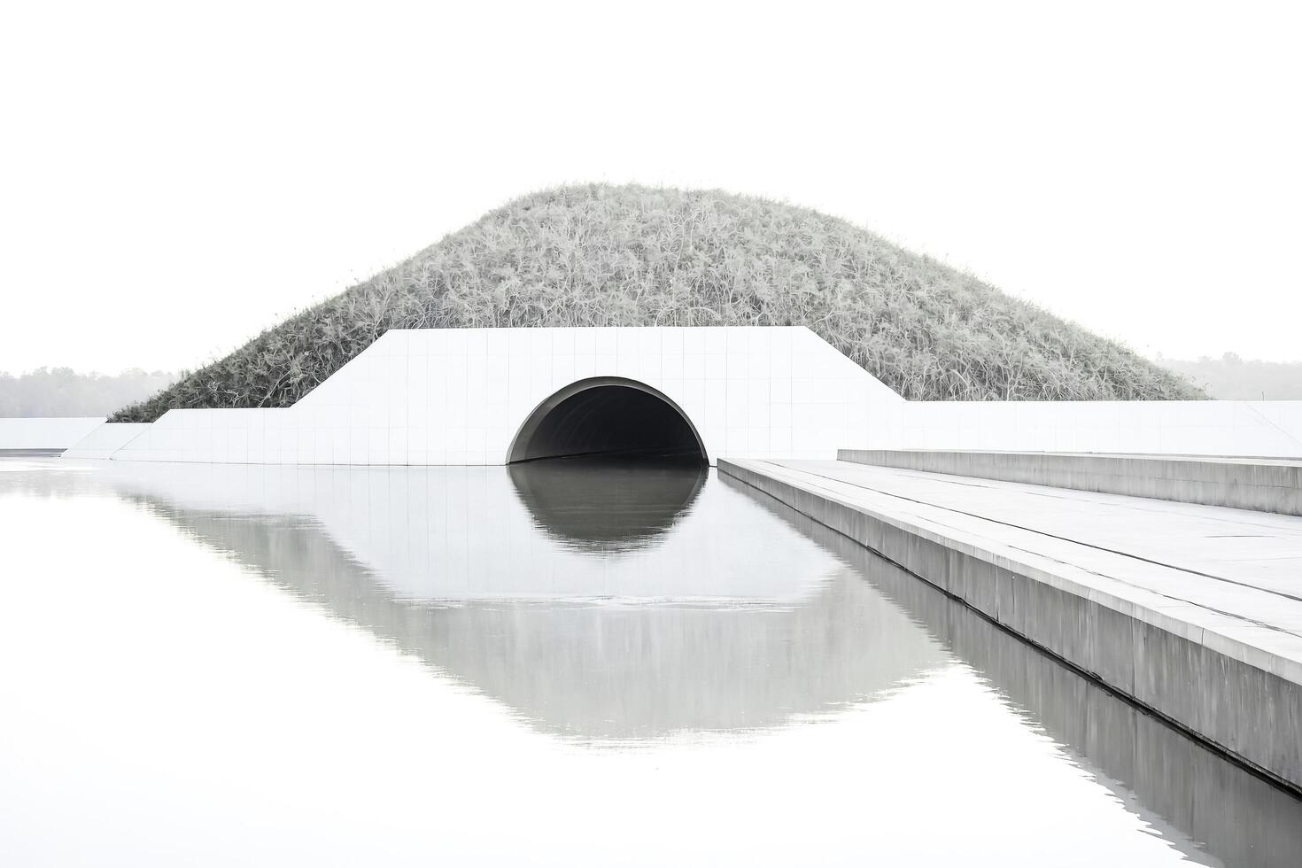 Minimalist Concrete Architecture with Tunnel and Water Reflection photo