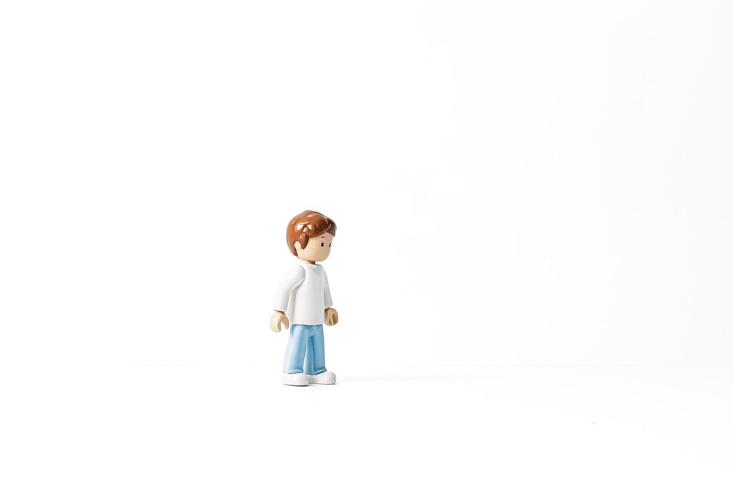 Toy figure of a boy standing on a white background photo