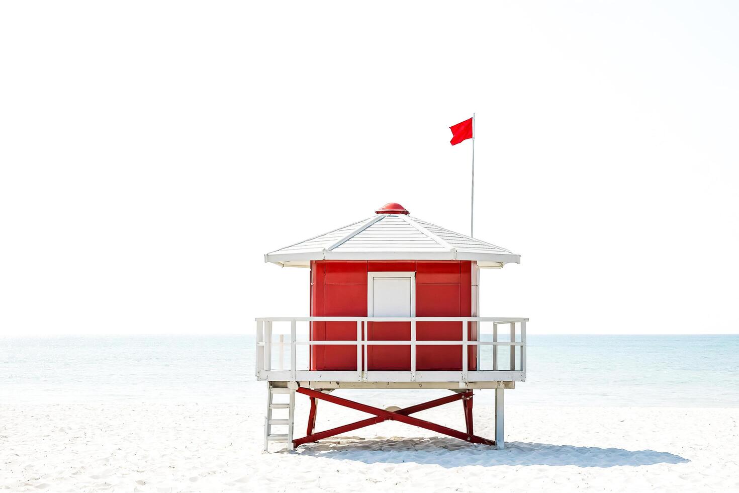 Red Lifeguard Stand on Sandy Beach with Blue Ocean photo