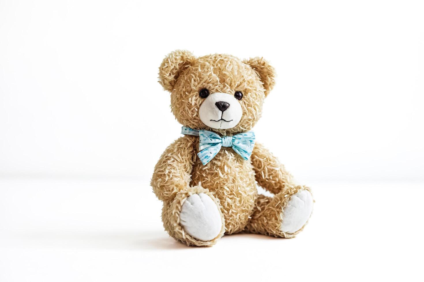 Teddy Bear with Blue Bow Tie on White Background photo