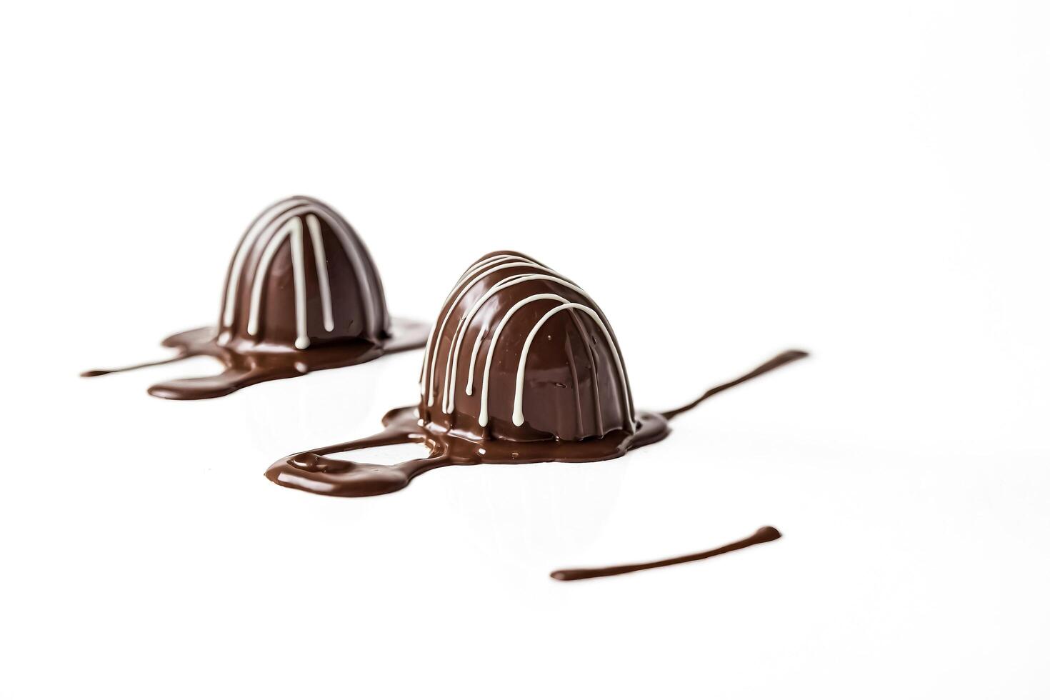 Two Melted Chocolate Bonbons with White Stripes photo