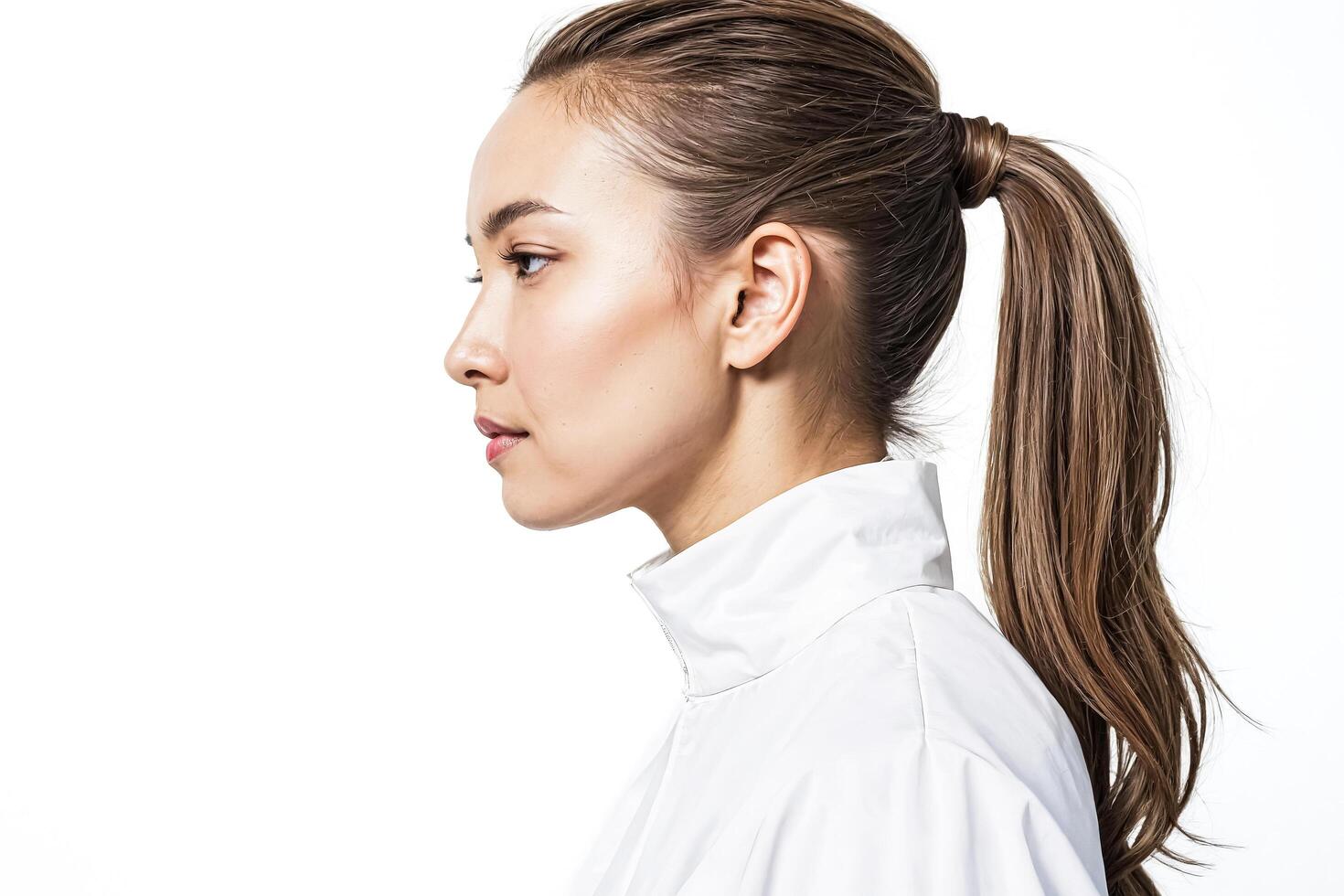 Woman with long brown hair in white shirt looking to the side photo