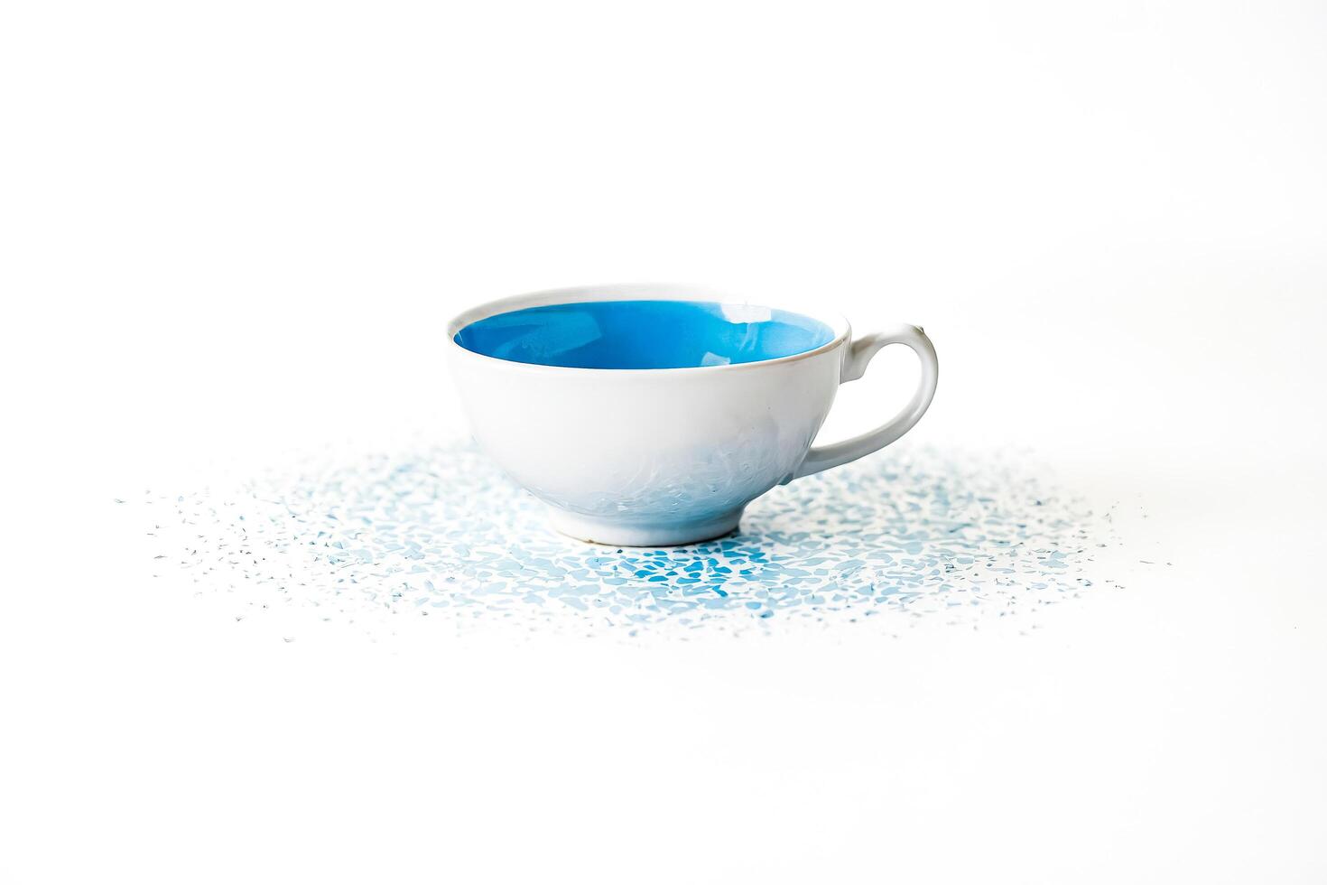 Blue Teacup with Spilled Blue Liquid photo