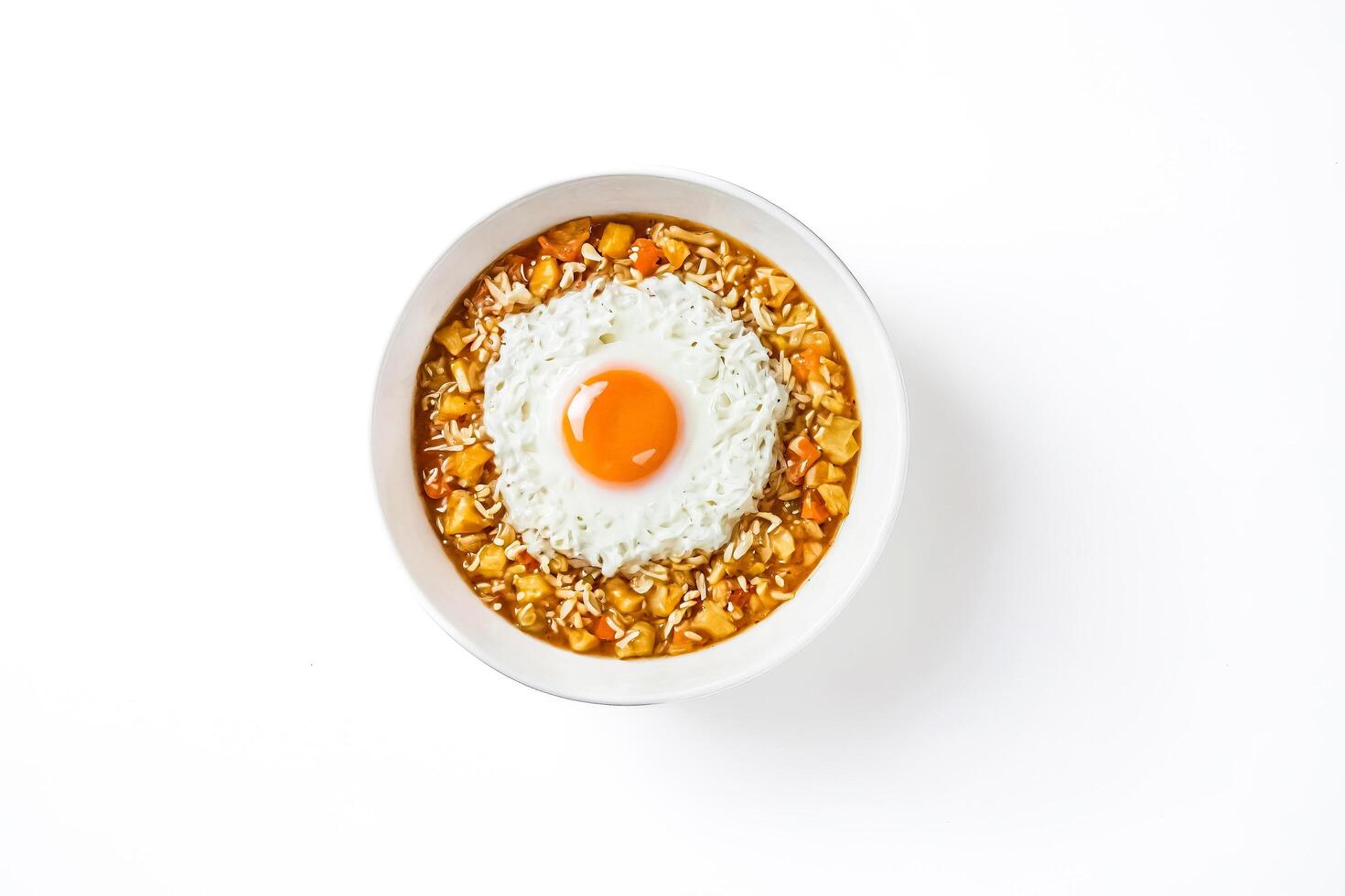 Fried egg on rice with curry sauce in a white bowl photo