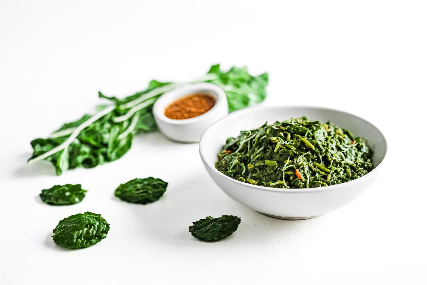 Closeup of a Bowl of Spinach Salad with Leaves Scattered Around photo
