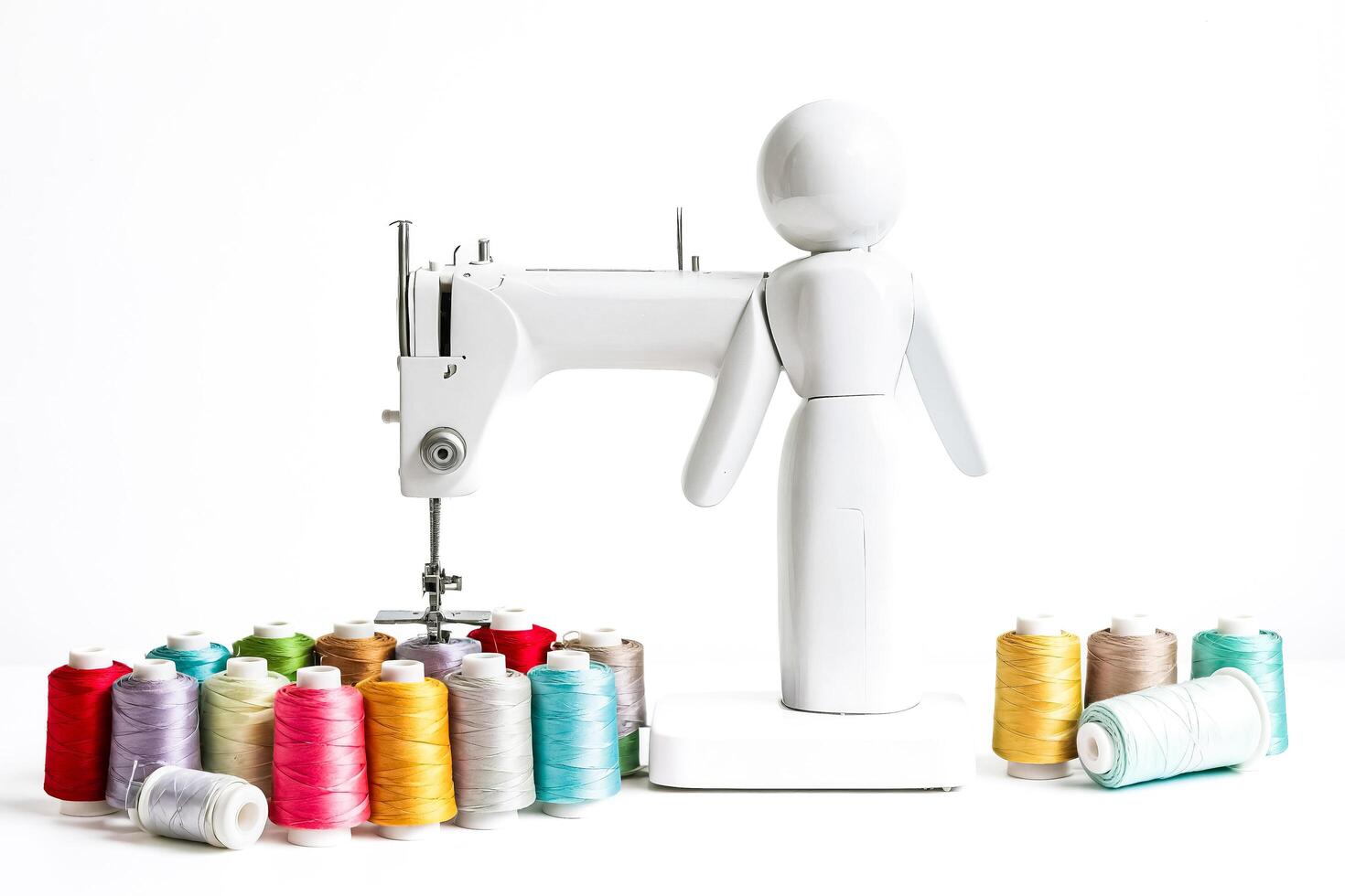 White sewing machine with colorful spools of thread photo