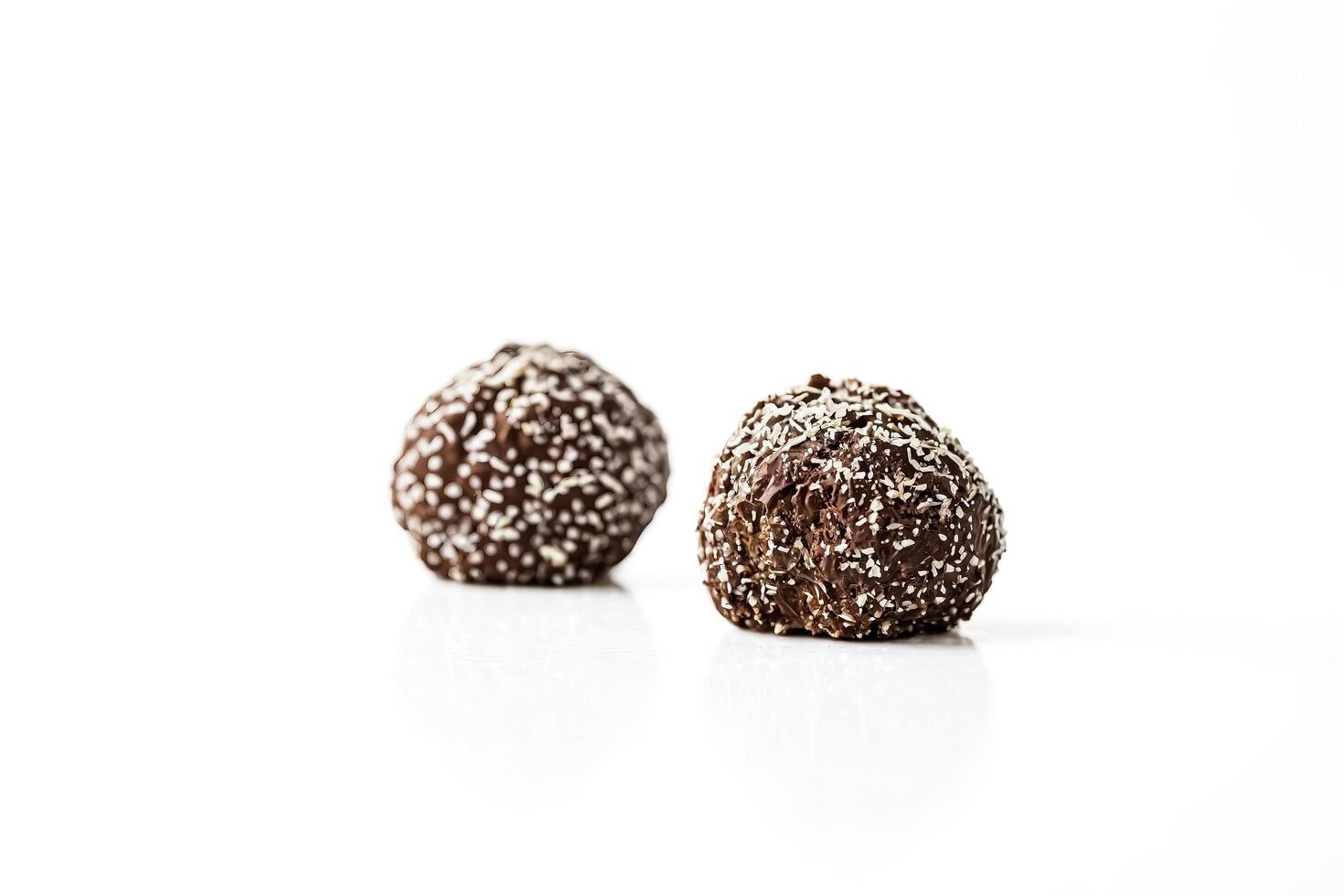 Chocolate truffles with coconut flakes isolated on white background photo