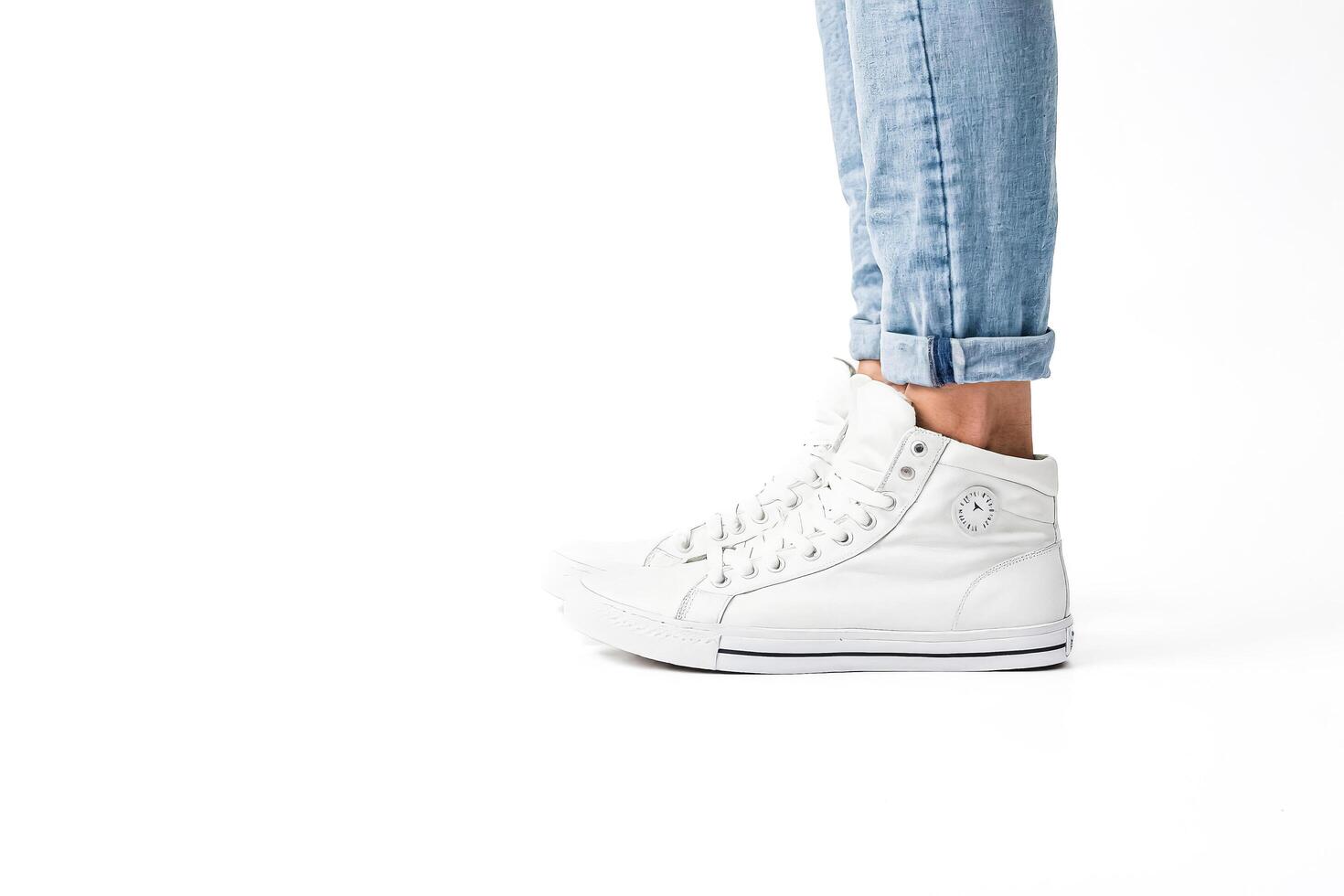 Closeup of White Leather Sneakers with Jeans on White Background photo
