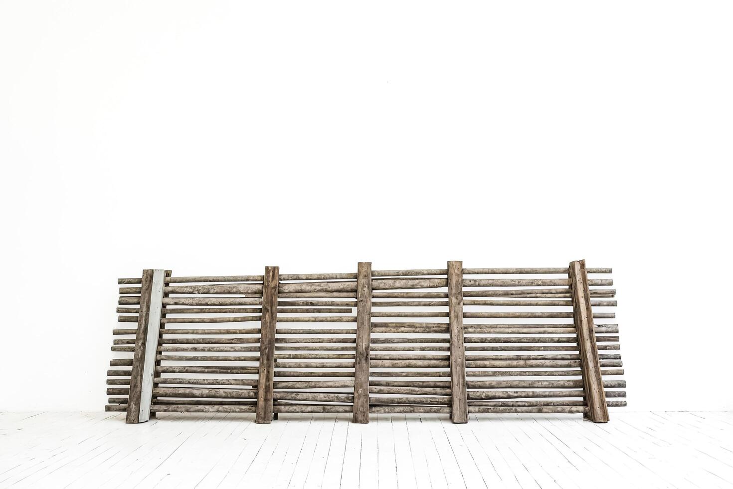 Rustic Wooden Fence Against White Wall photo