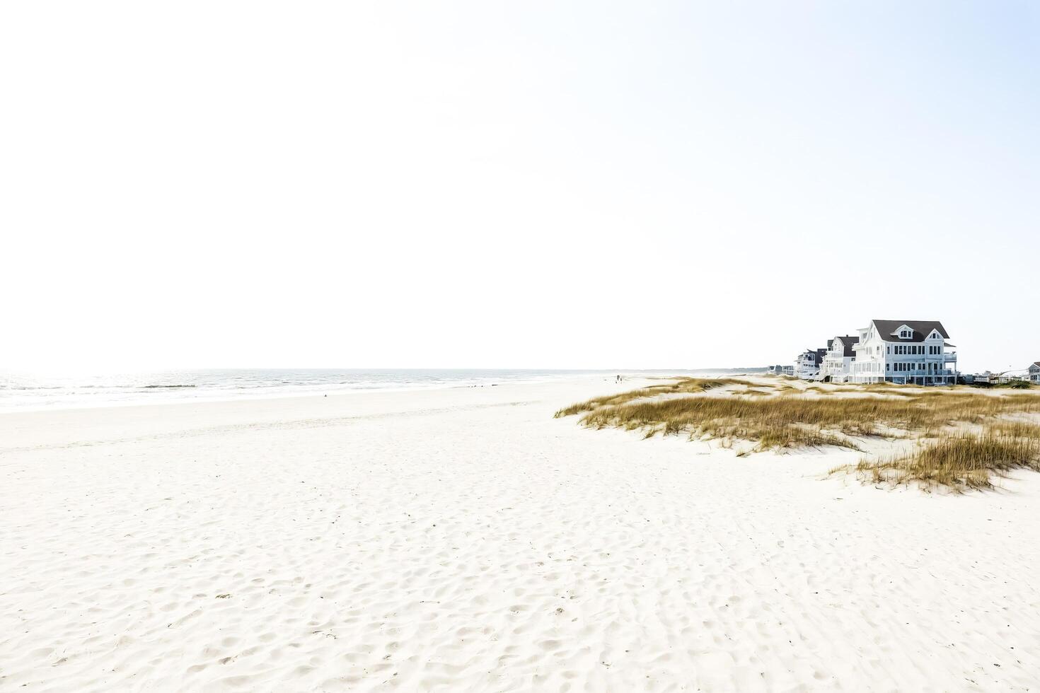 Beach house with white sand and blue sky photo