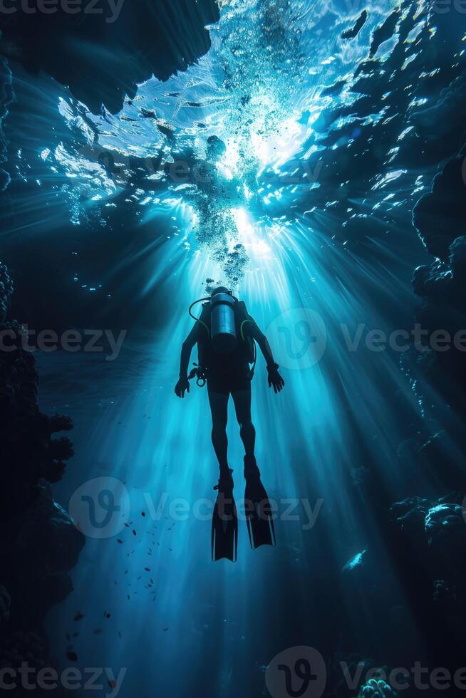 diver underwater, silhouette and sun light. photo
