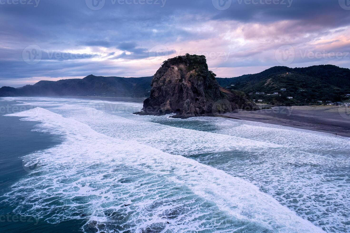 Beautiful iconic Lion Rock and breaking wave on Piha beach in the evening at Auckland, New Zealand photo