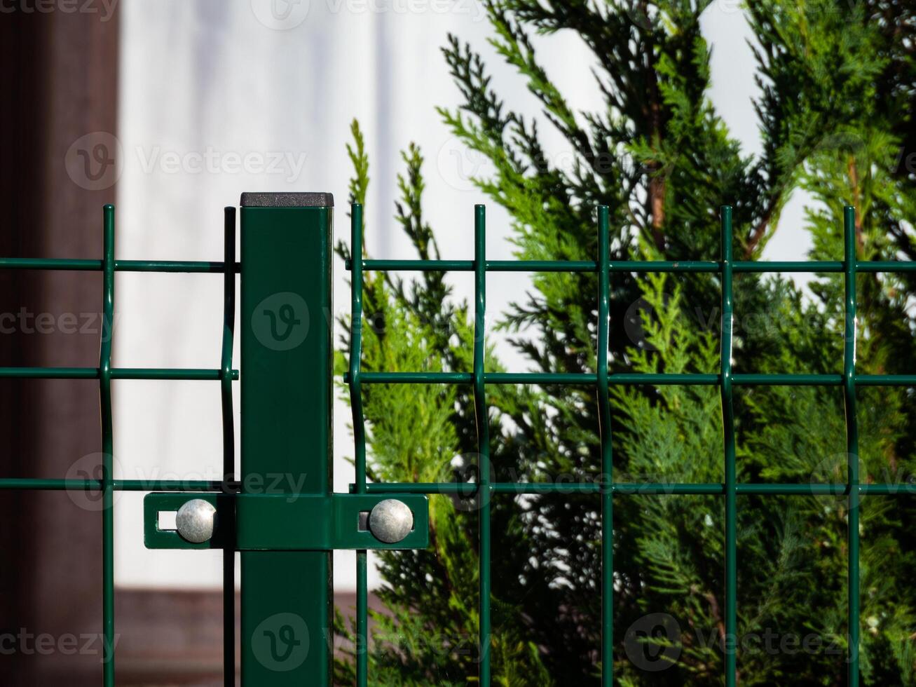 green iron fence with mesh on posts close up photo