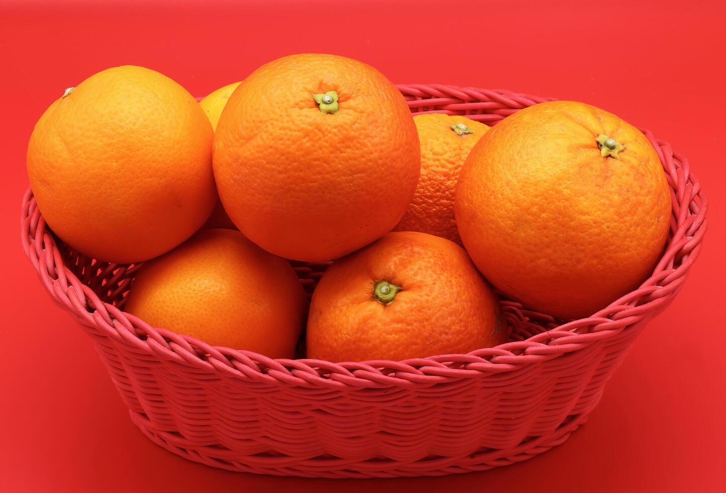 Fresh oranges isolated on red background. photo