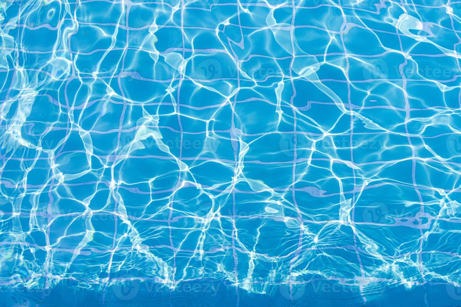 Blue swimming pool water surface and ripple wave background. Summer abstract reflection caustics in swimming pool. photo
