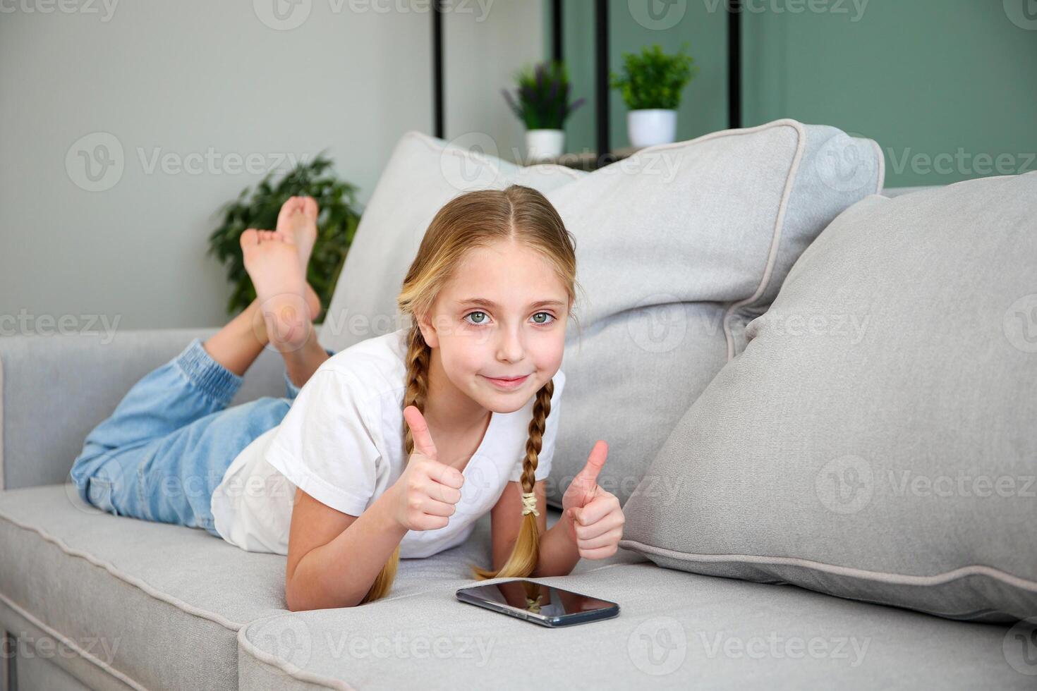 Child play with a mobile phone at home. photo