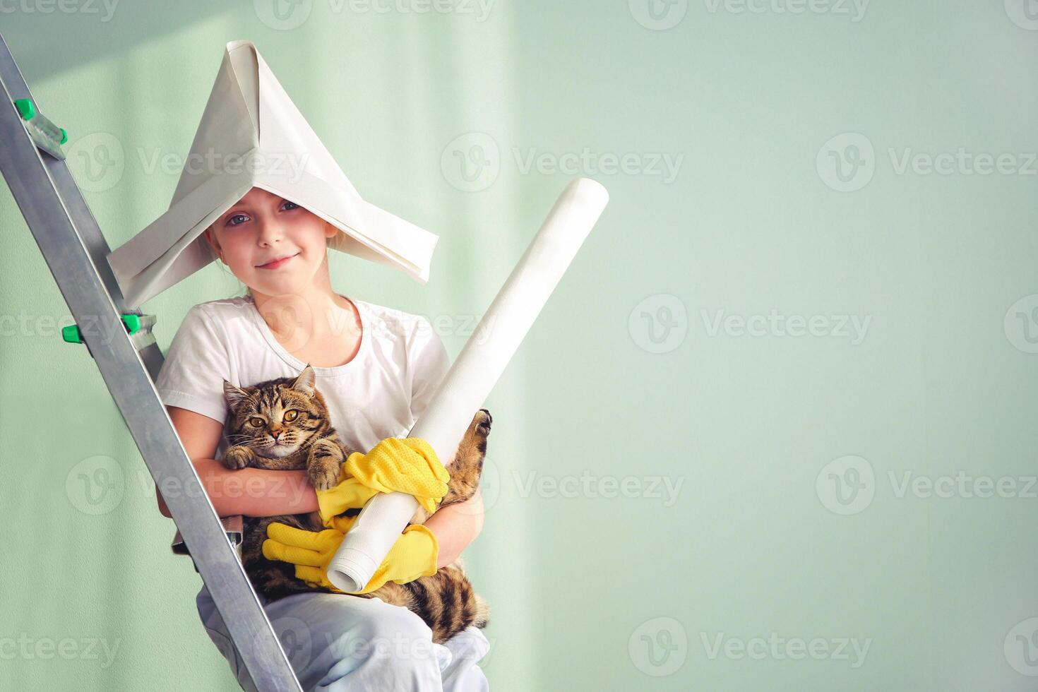 A girl and a cat are sitting on a stepladder. The child has wallpaper in his hands. The concept of home renovation. Place for texts. Tinted image. photo