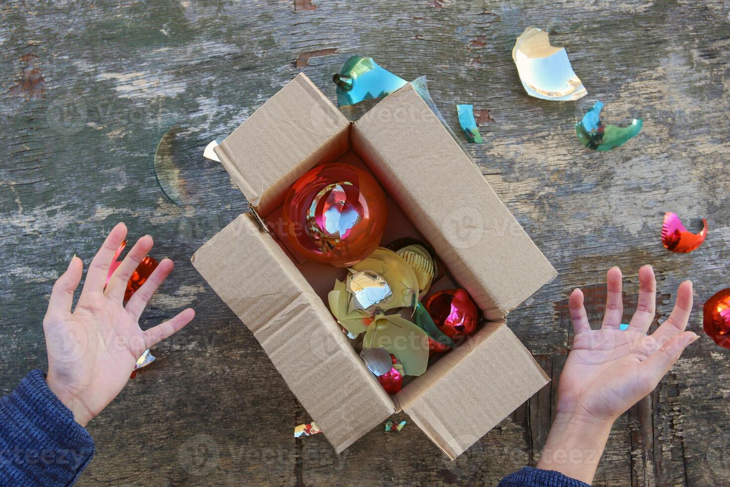 A woman received a parcel with broken Christmas tree glass balls. The concept of a bad packing of goods. photo