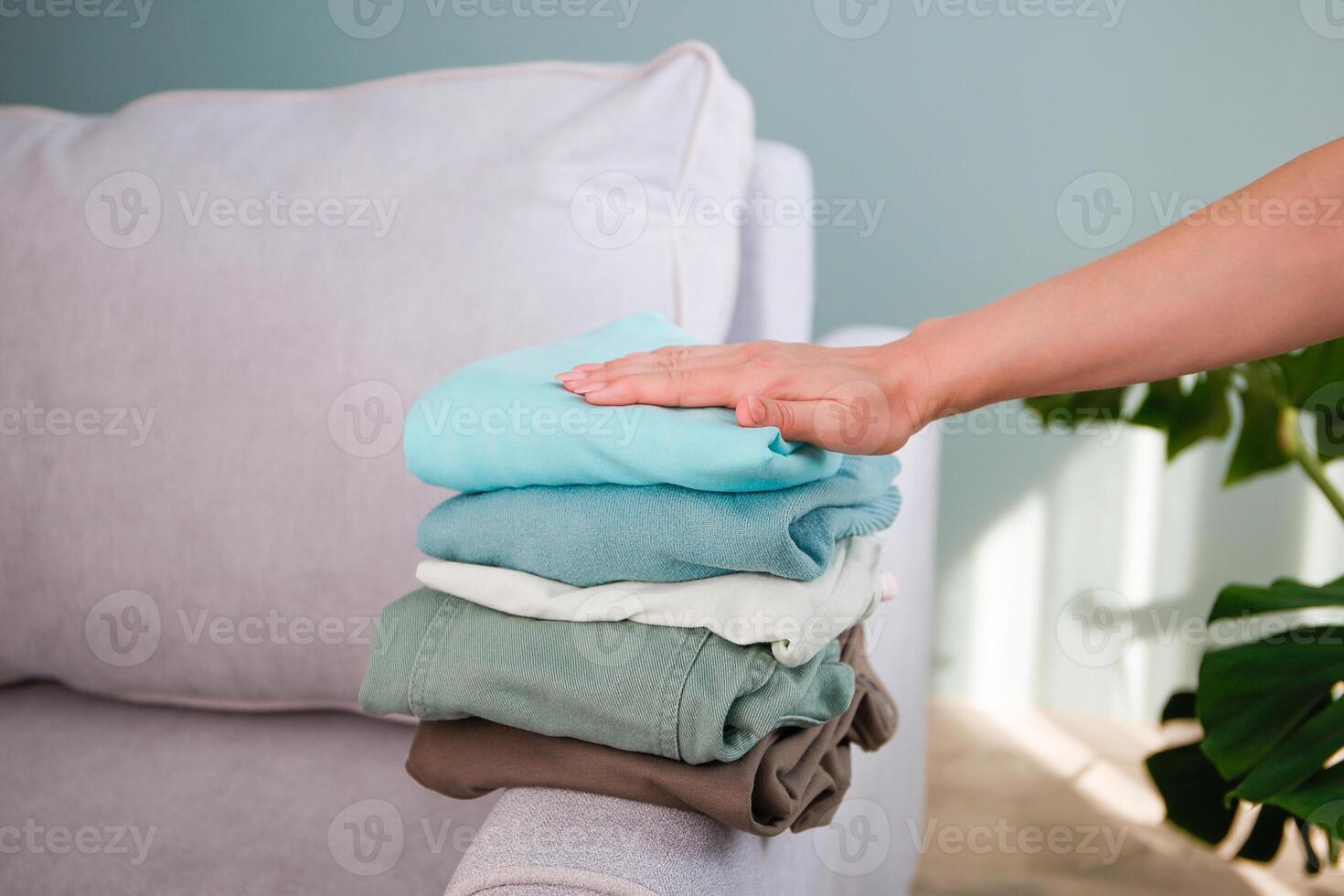 Pile of colorful warm clothes on the grey sofa. photo