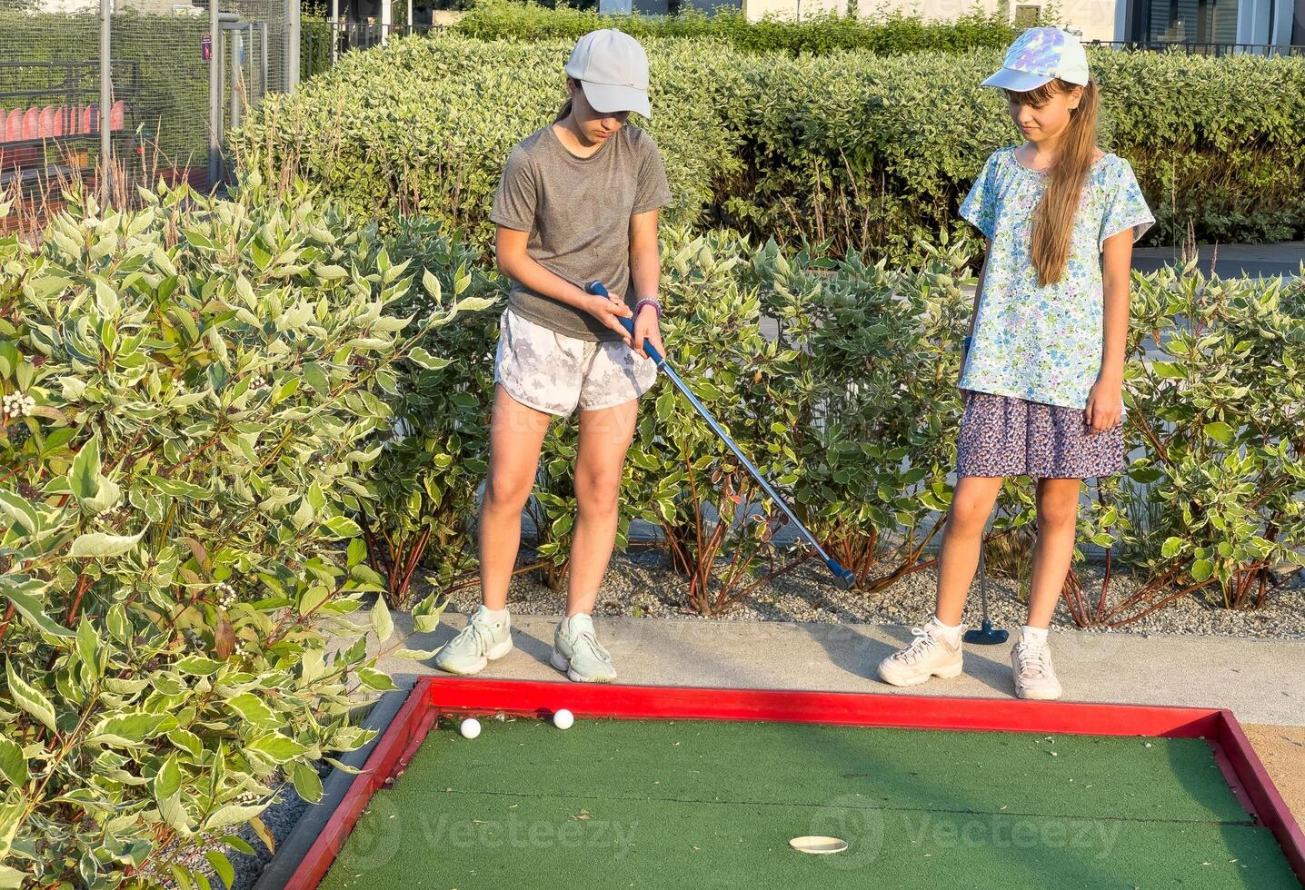 teenage girls play mini golf photo