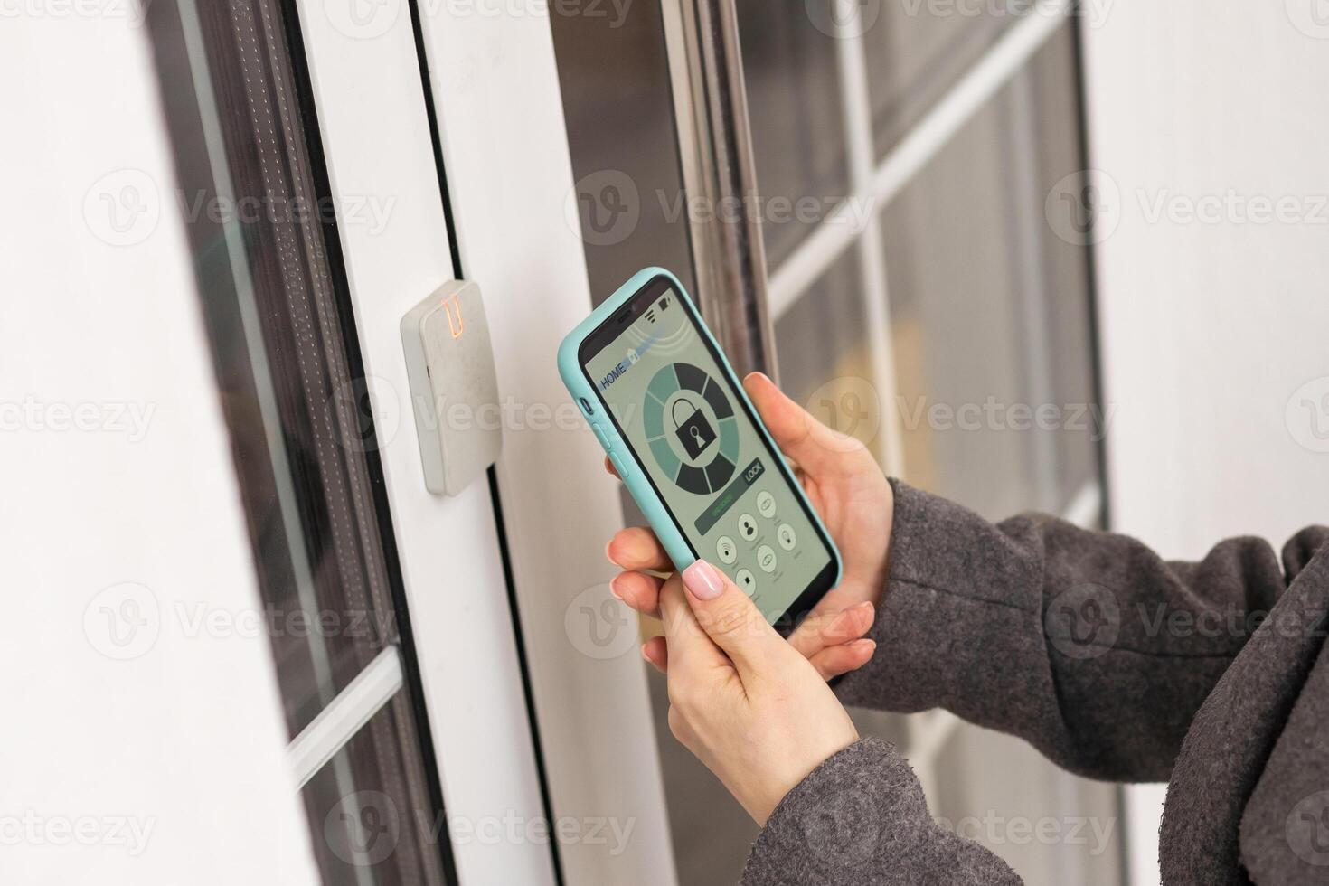 Smiling woman setting home security system with help of mobile application. photo