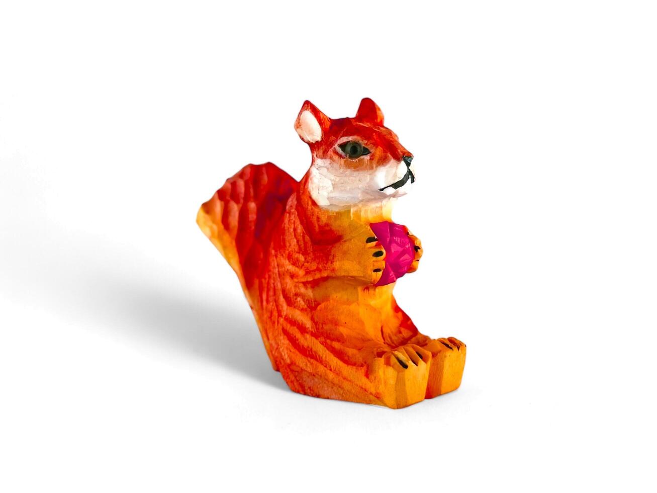miniature wooden squirrel statue on a white background photo