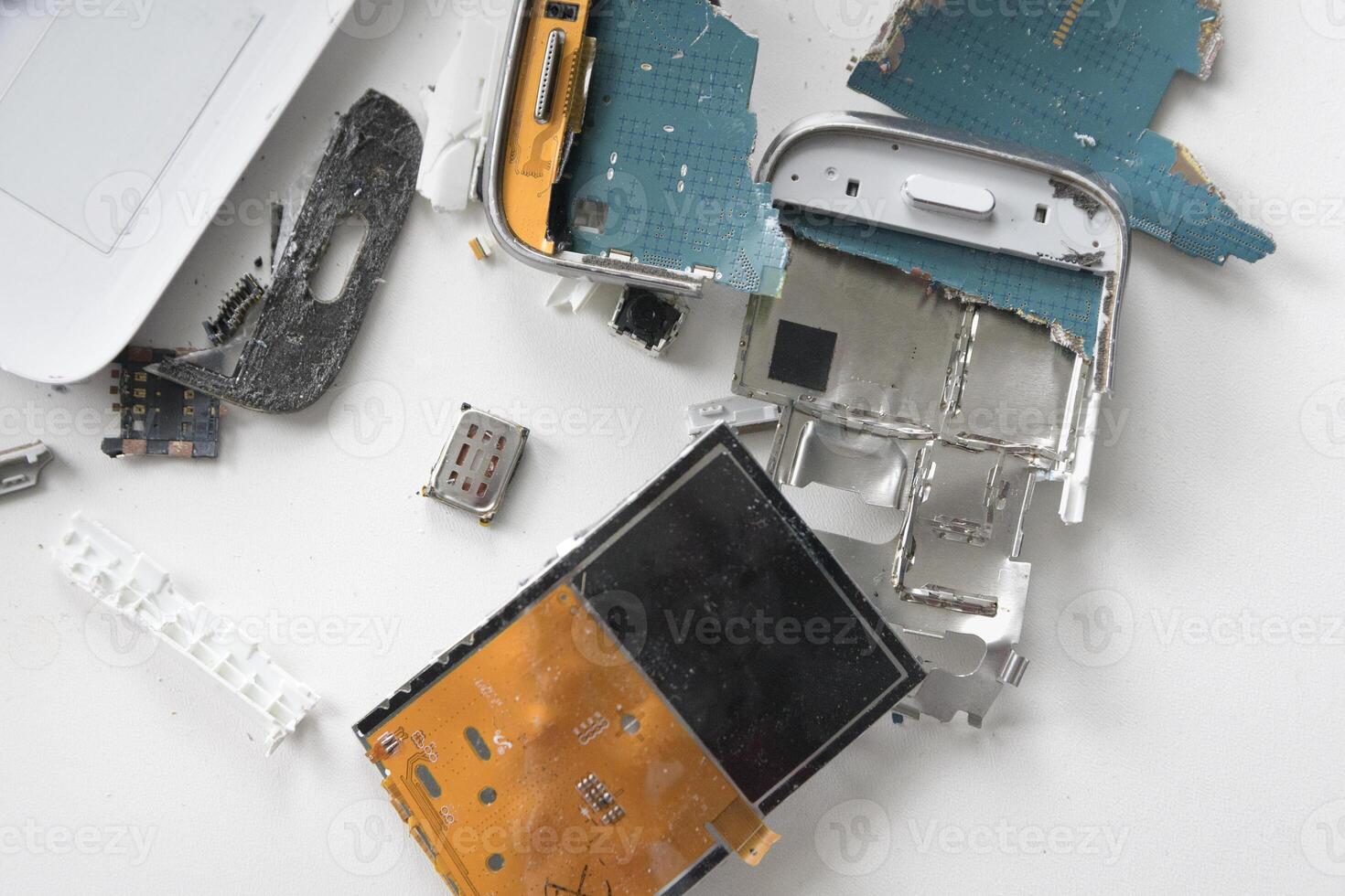 Broken smartphone. The insides of a dropped smartphone in a white case. close-up top view photo