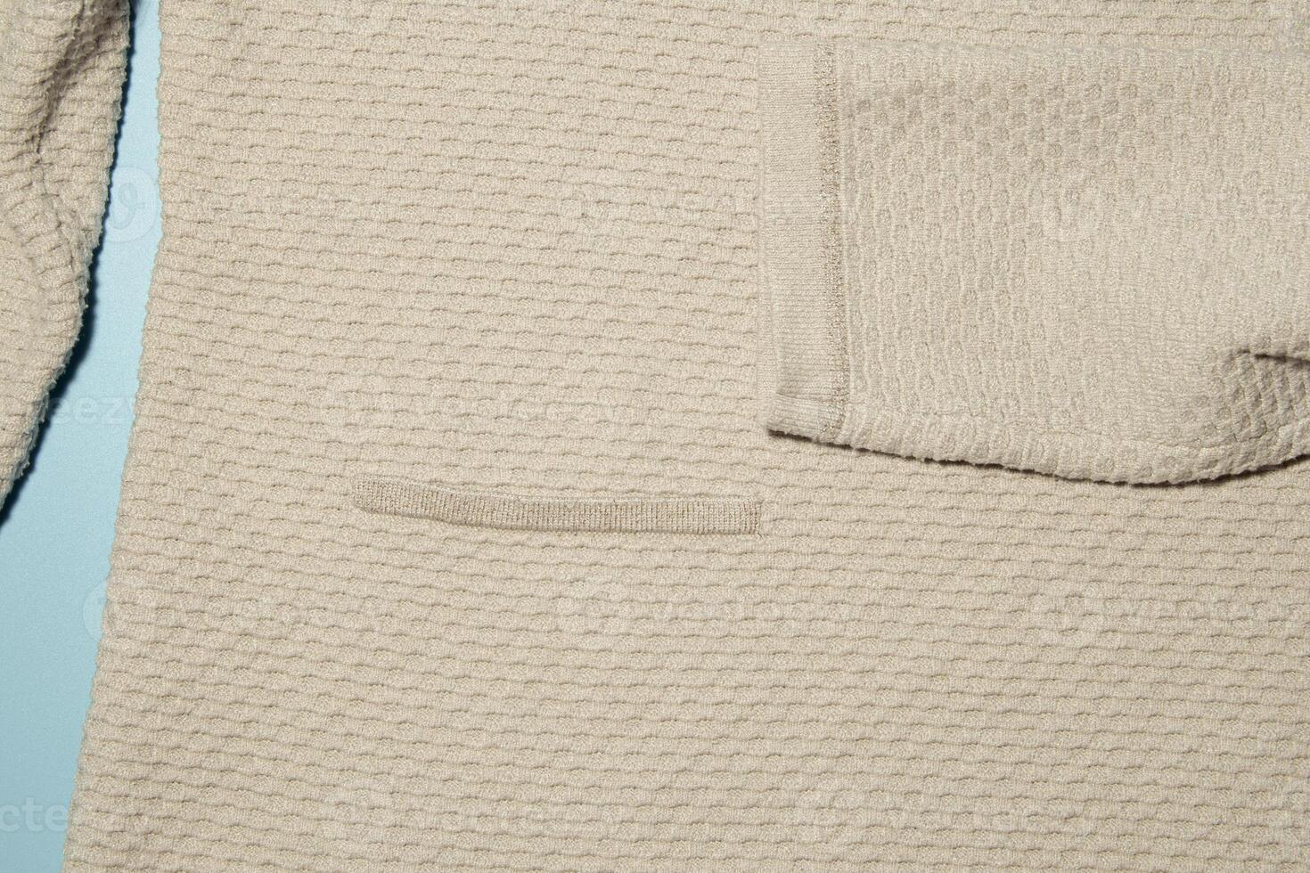 Texture of a knitted sweater with a fragment of a sleeve and a pocket photo