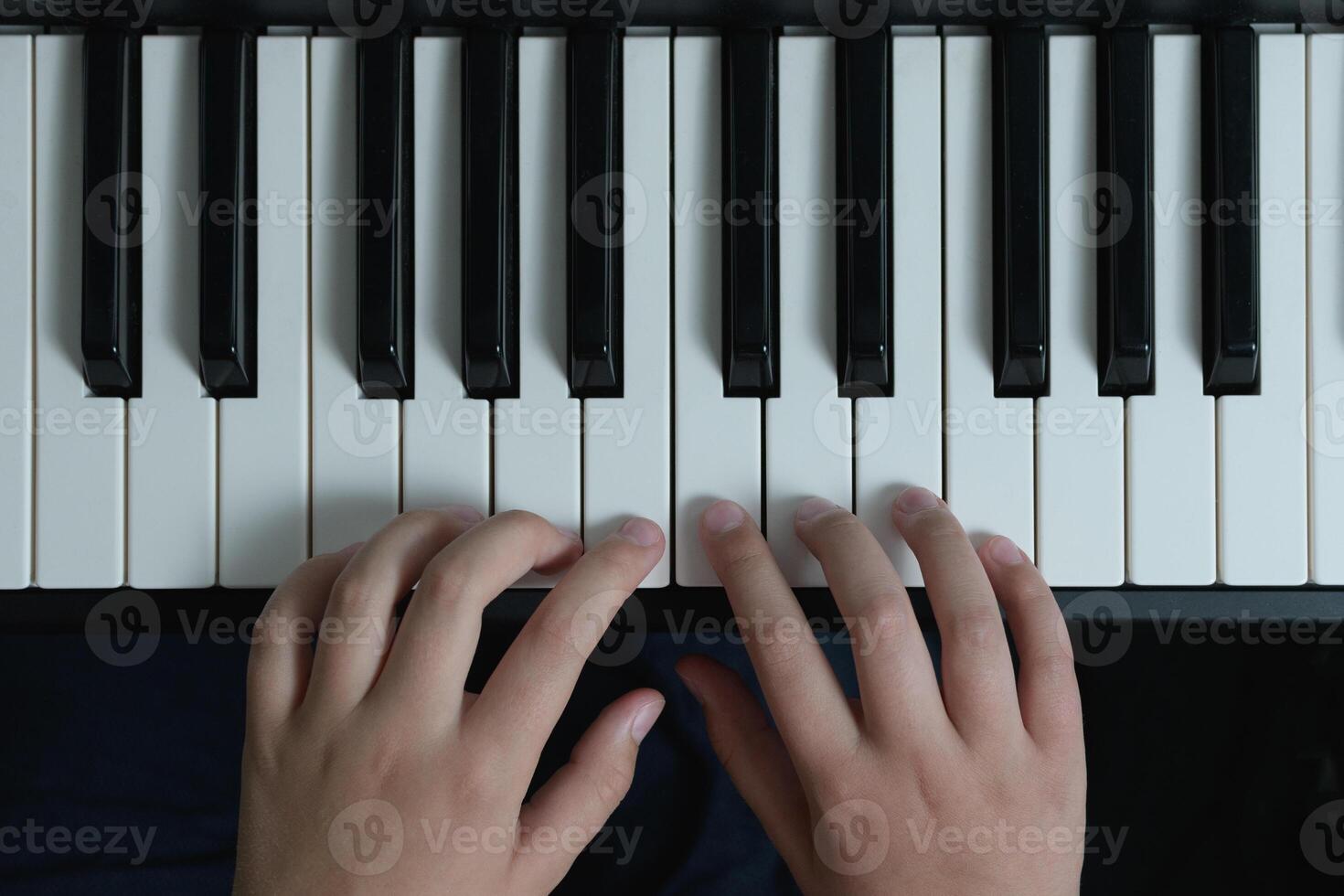 Piano chords and scales. Music exercises. Two hands playing. Keyboard close-up photo