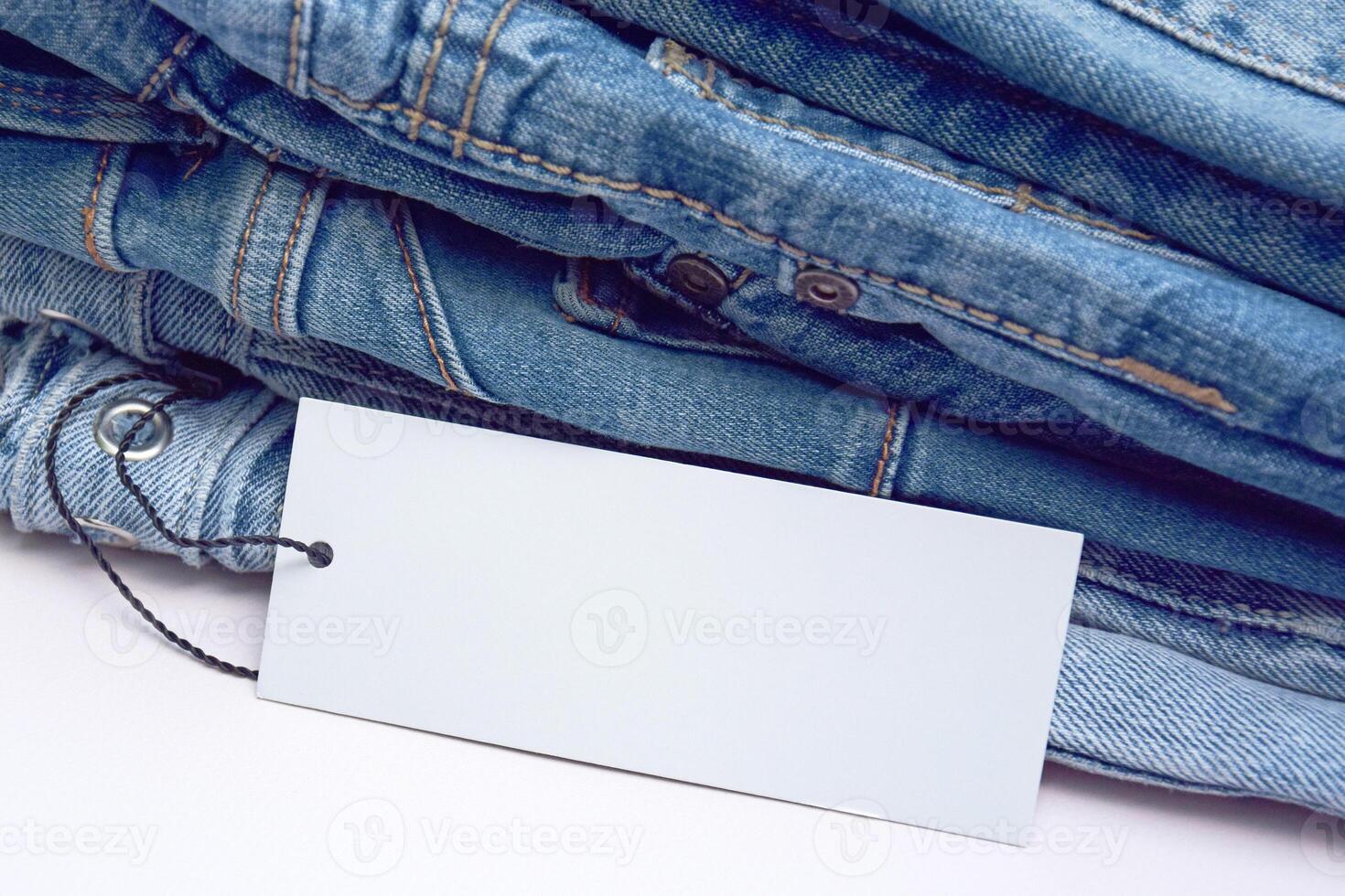 Lots of jeans pants in a stack. Denim background. photo
