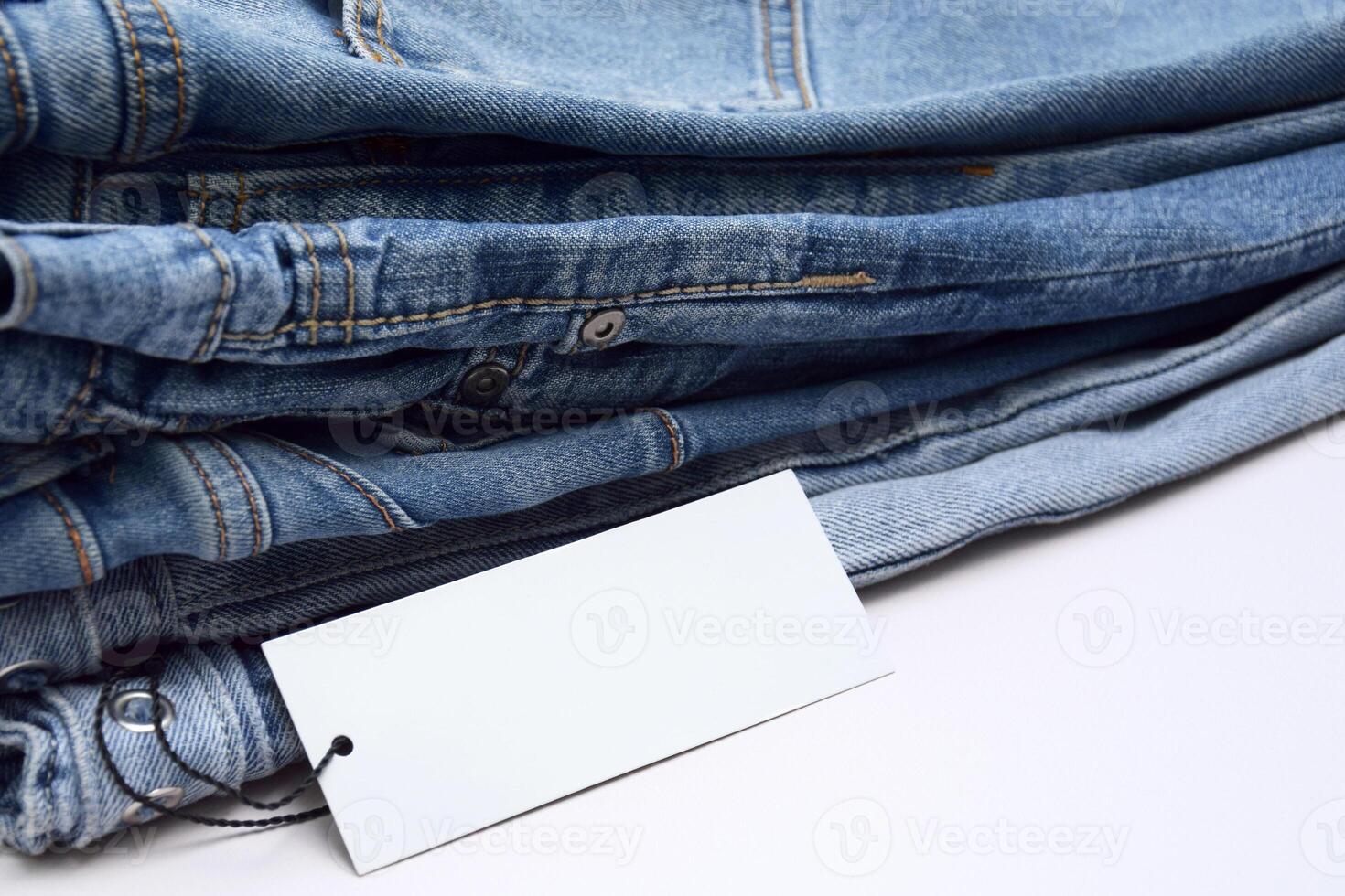 Lots of jeans pants in a stack. Denim background. photo