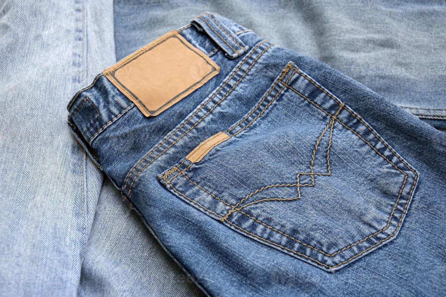 Lots of jeans pants in a stack. Denim background. photo