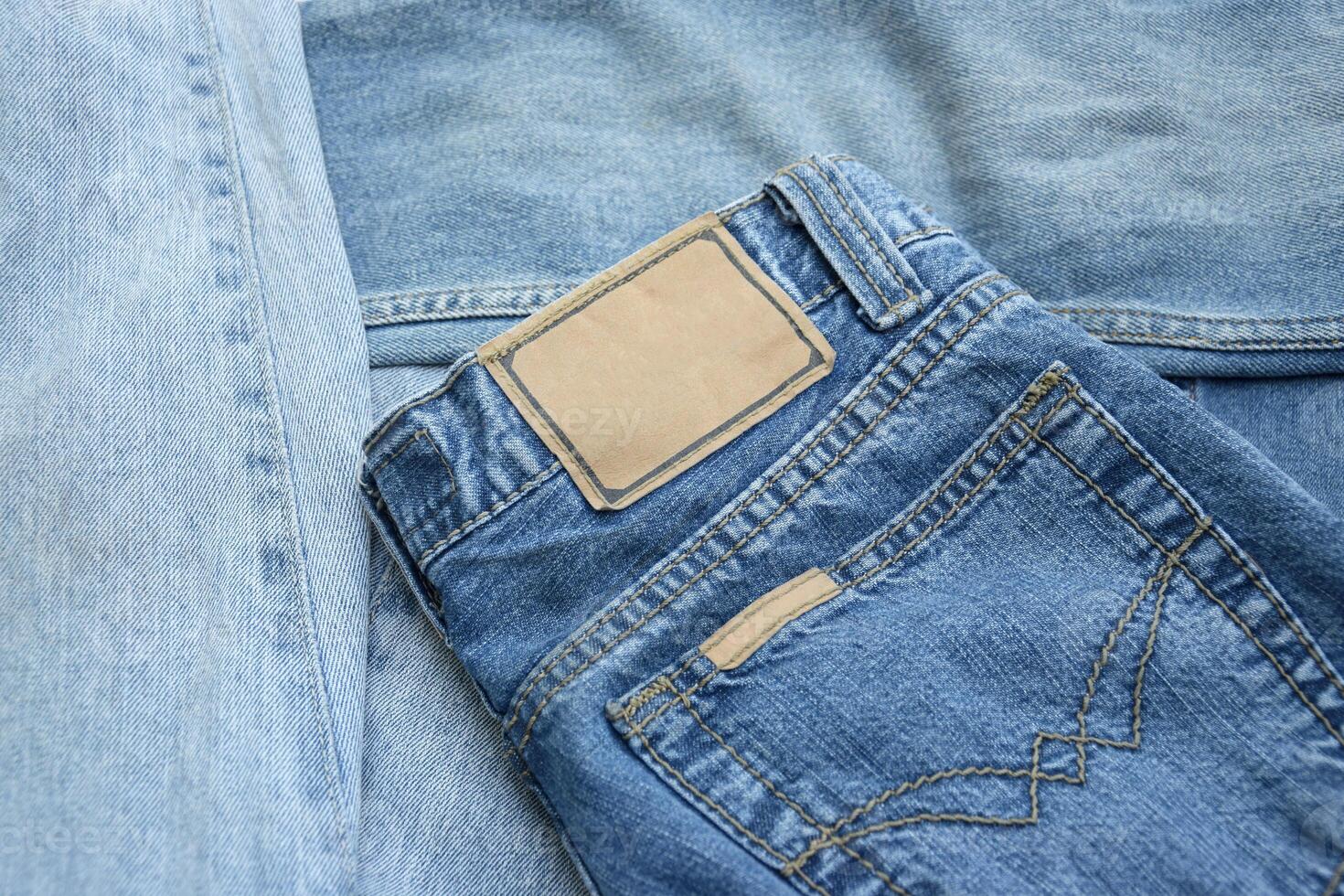Lots of jeans pants in a stack. Denim background. photo