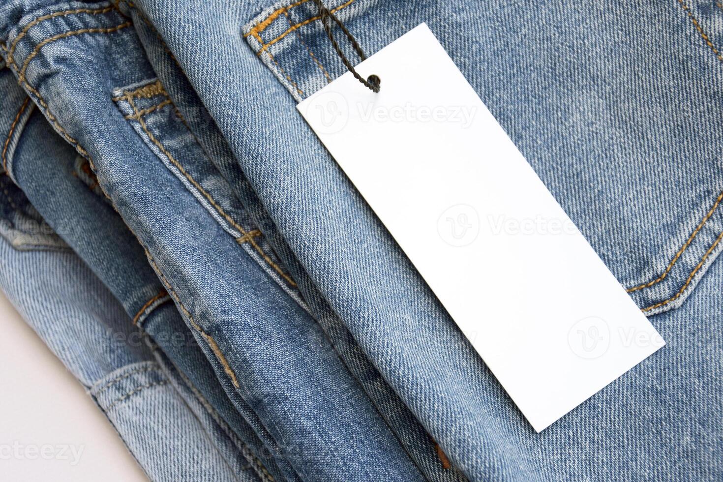 Lots of jeans pants in a stack. Denim background. photo