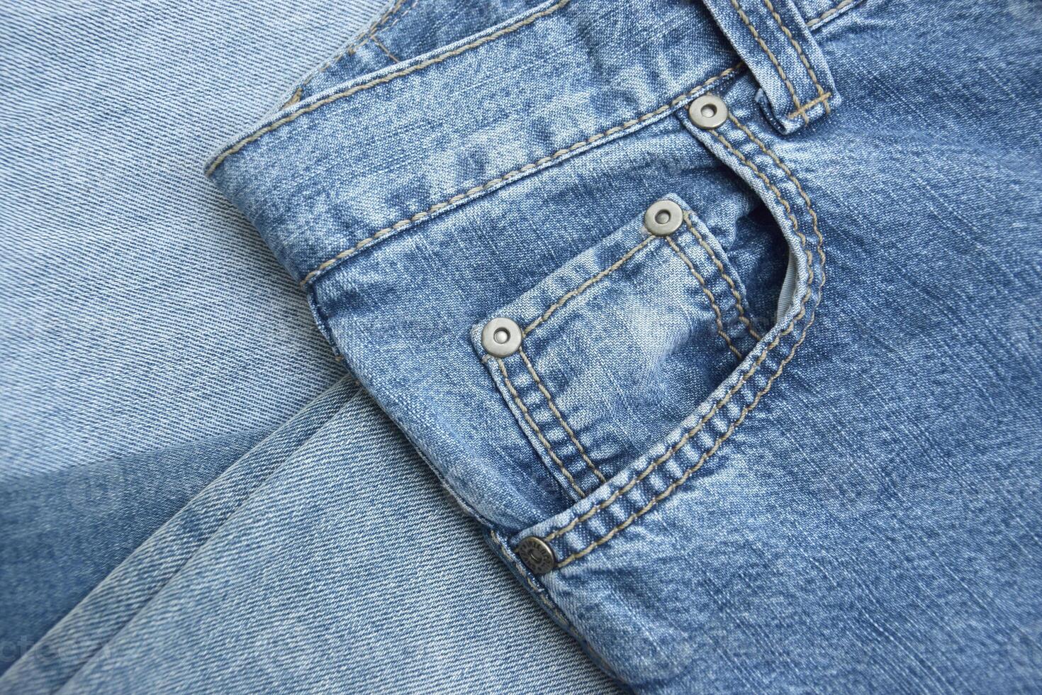 Lots of jeans pants in a stack. Denim background. photo