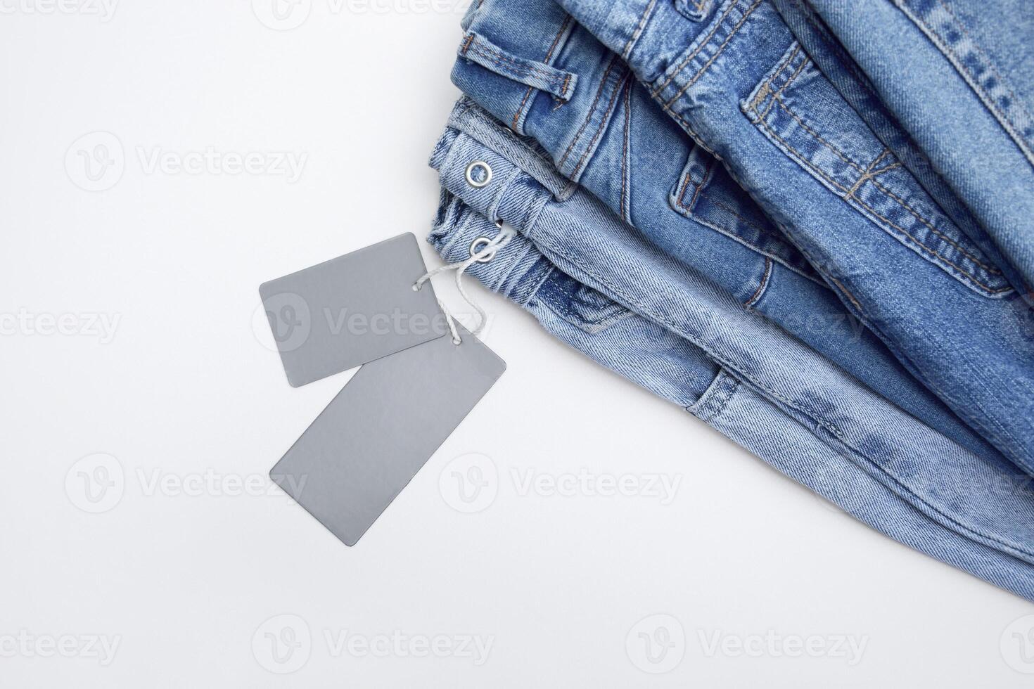 Lots of jeans pants in a stack. Denim background. photo