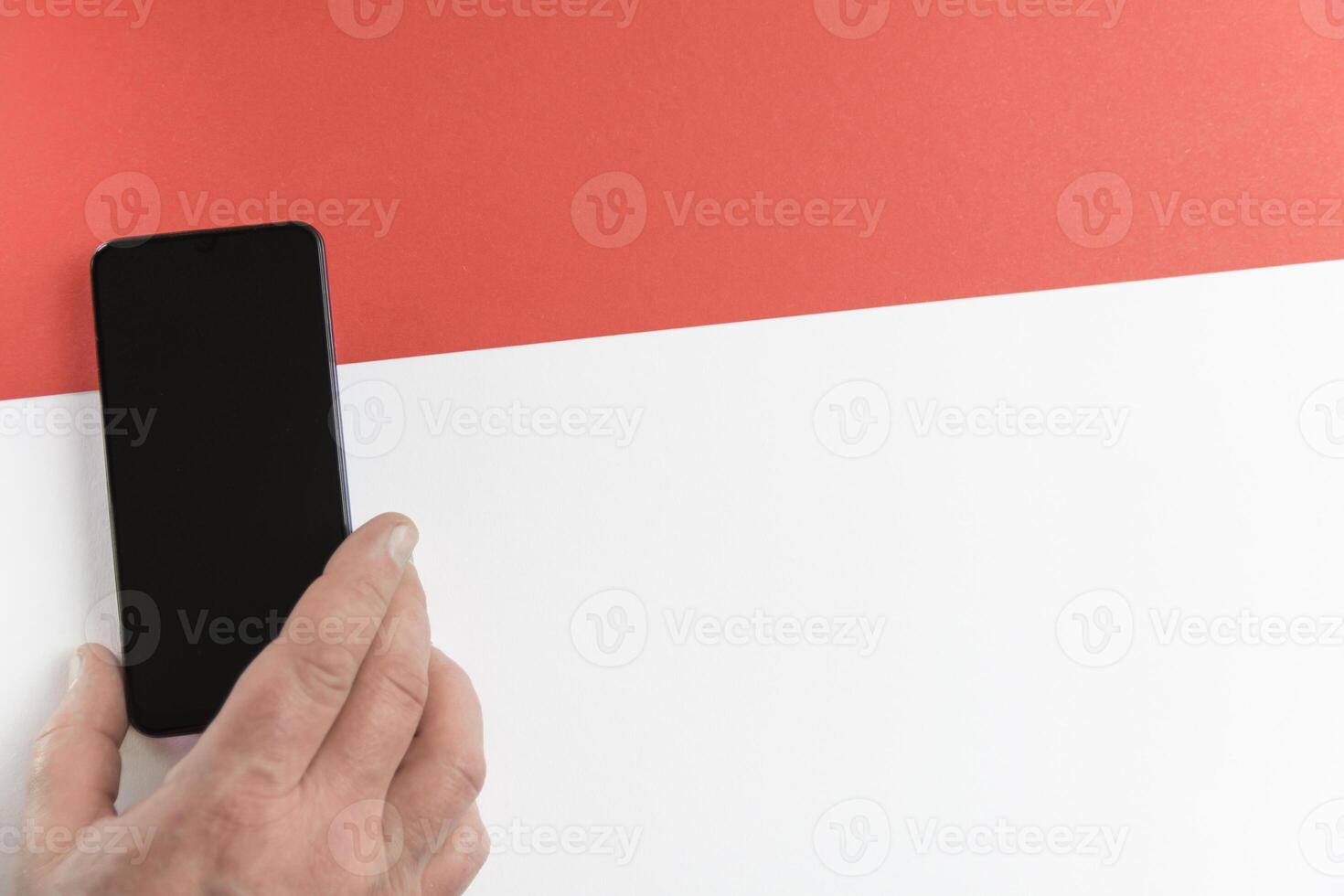 Red line. Hand with smartphone on red and white background. photo